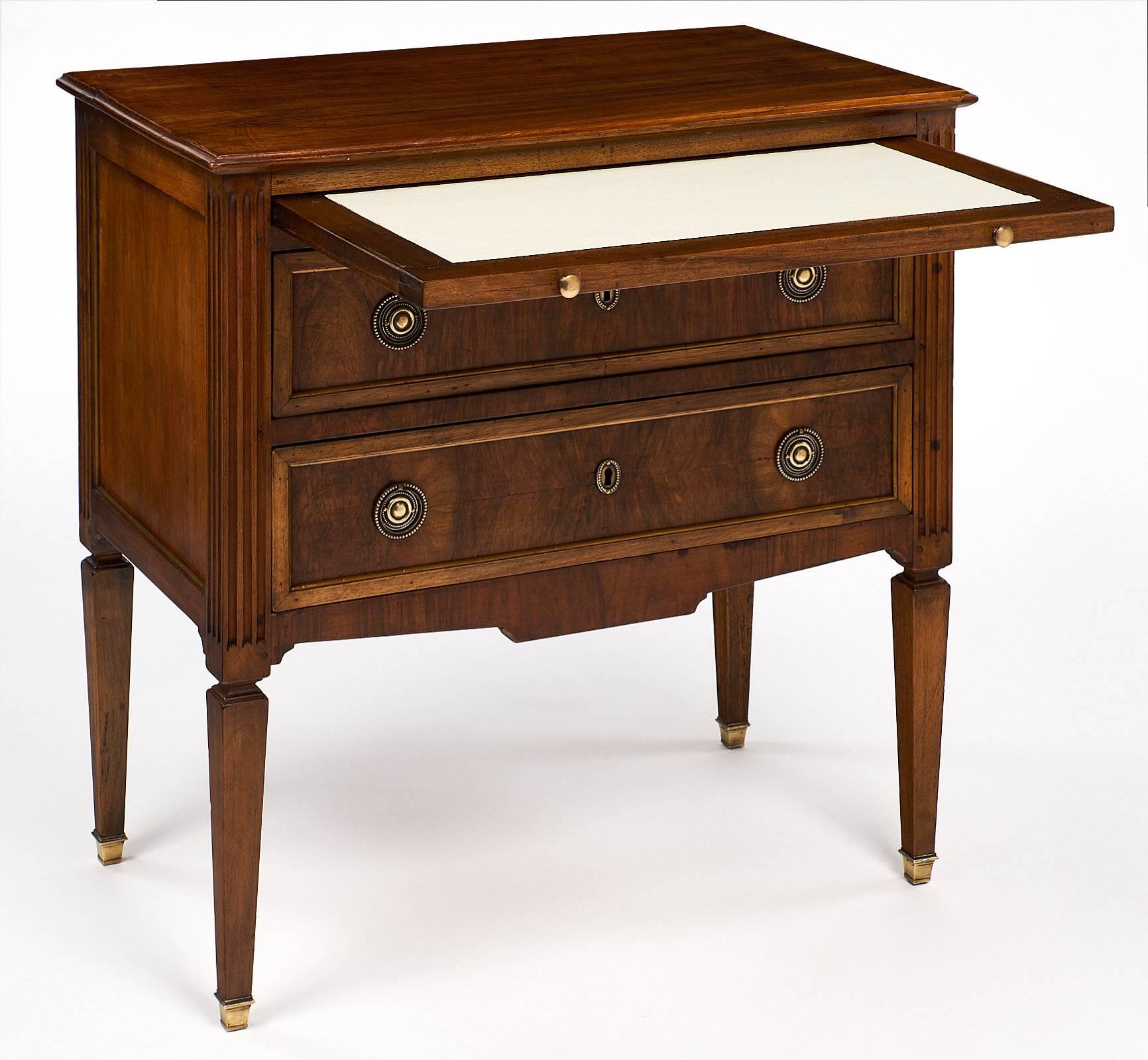 This elegant Louis XVI style chest has a nice plank top of figured walnut and finely cast bronze hardware. This piece features a wonderful pull-out leaf with an ivory colored leather writing surface. The pull-out leaf is 27.5” wide and 13.75” deep.