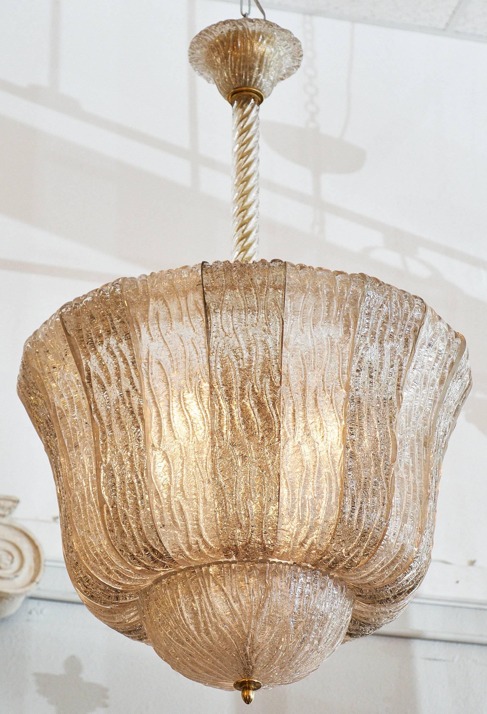 A superb two-tone lantern of stamped Murano glass. The glass alternates between a clear and smoke tone. The beautiful bell shape of the fixtures hangs from a brass rod concealed inside a torsado glass tube. This Barovier piece has been rewired for