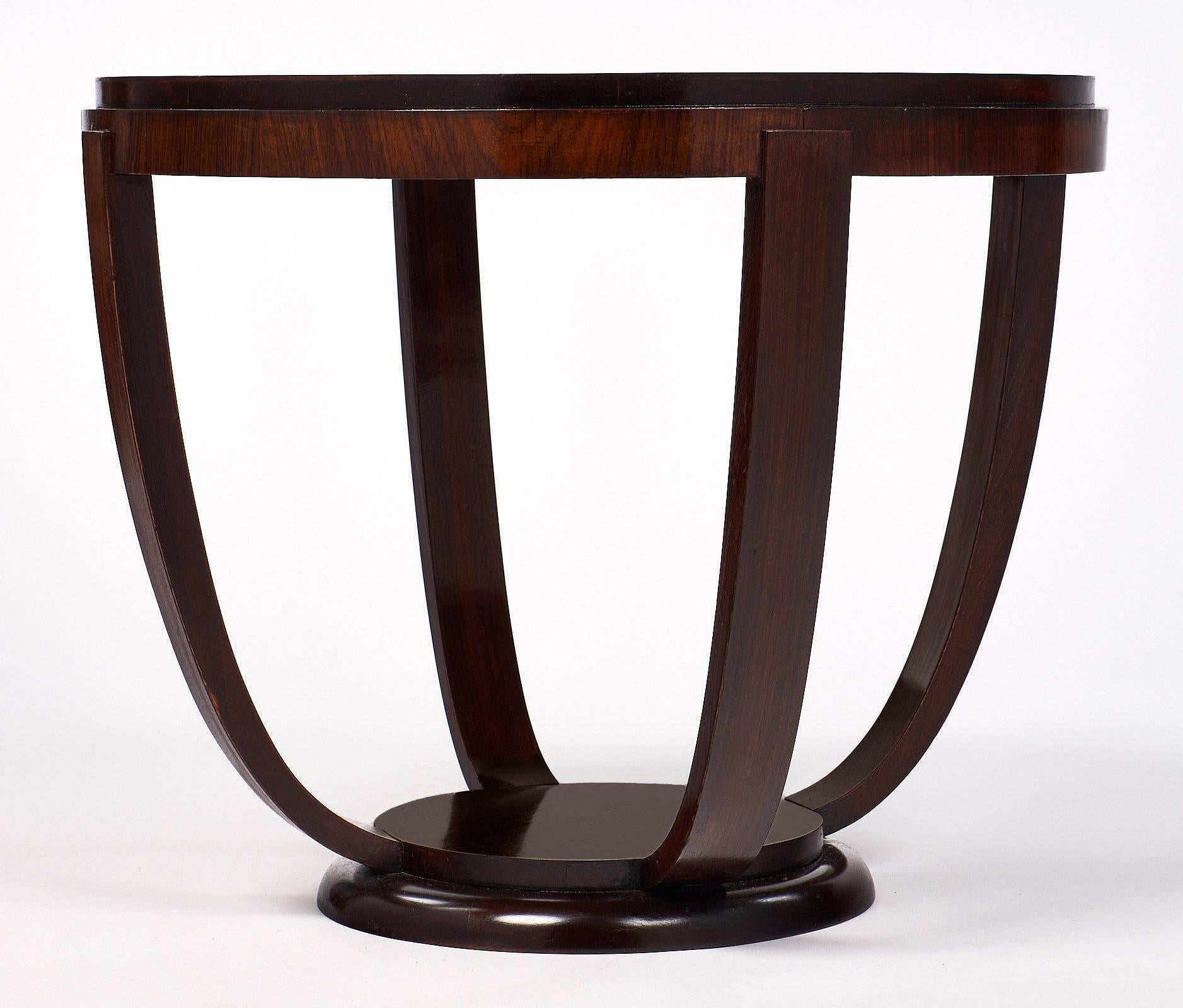This mahogany gueridon has the simple, curved lines and beautiful wood that is seen in Art Deco period pieces. The table is a great size for beside an armchair or sofa. The circular top is supported by four legs that curve down to a small circular