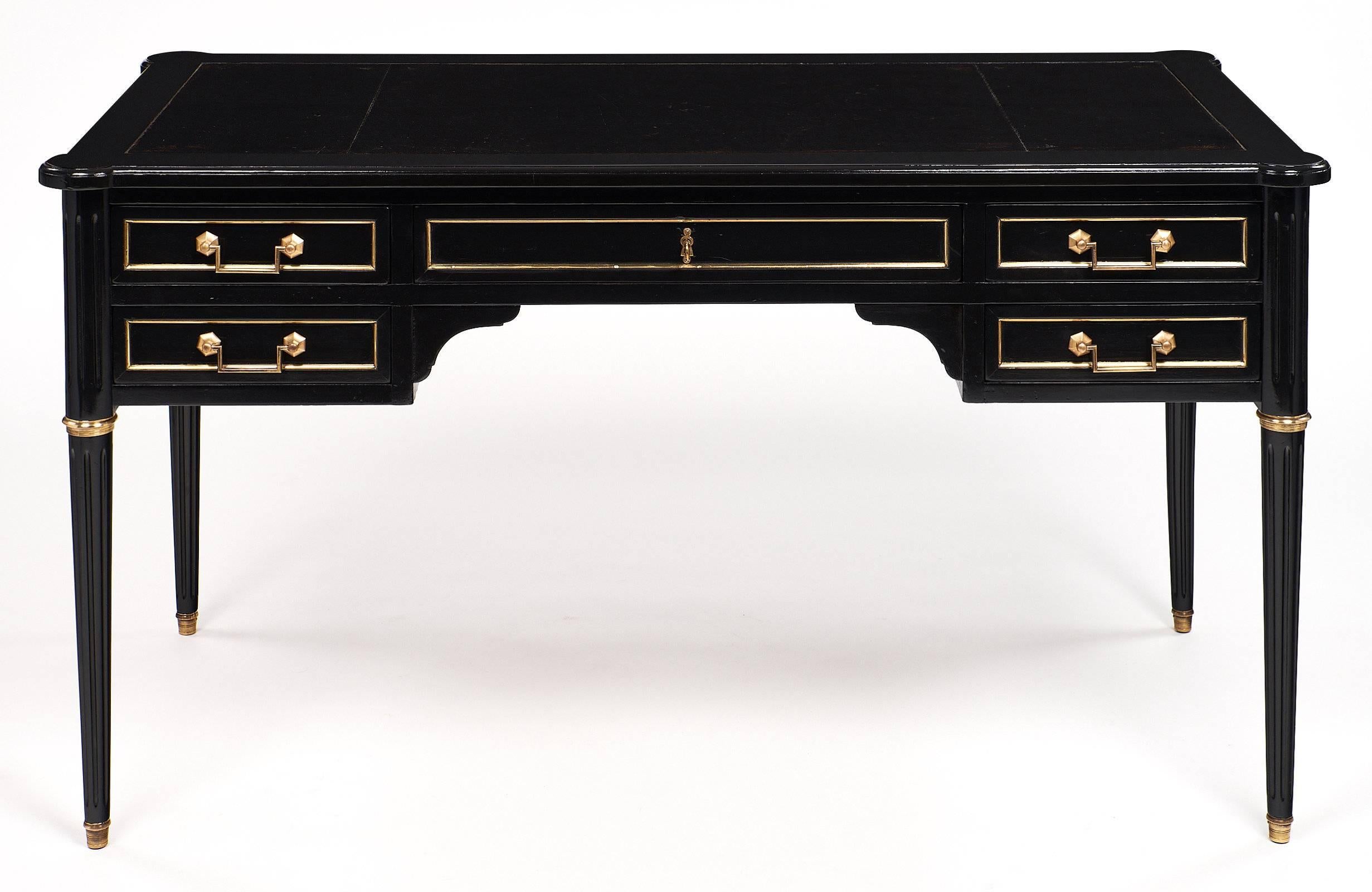 Great Louis XVI style desk with impressive size and wonderful details. This piece is made of solid mahogany that has been ebonized and finished with a French polish for a museum quality luster. The desk has hand-carved tapered and fluted legs capped