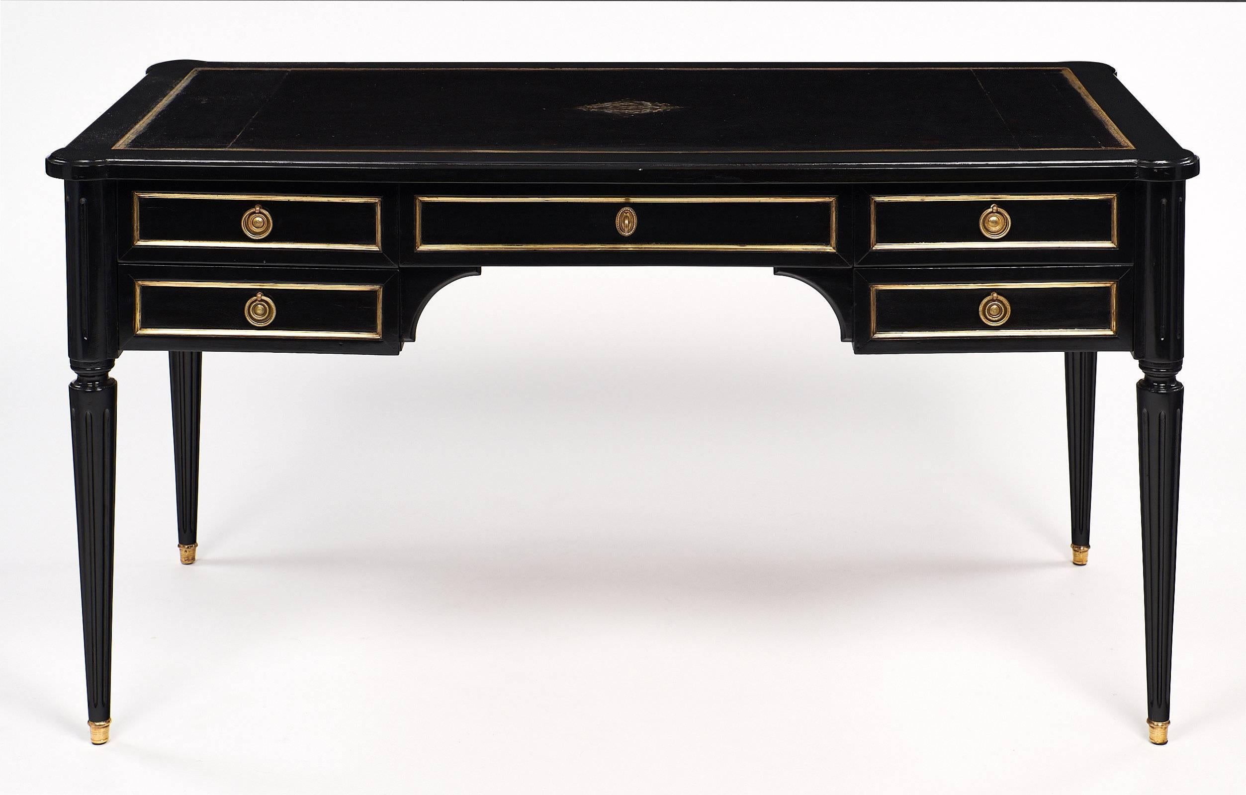 Wonderful desk made of ebonized mahogany and finished with a museum quality French polish for luster. This piece has the original black leather writing surface and two pull-out leaves, each covered with the same black leather. The leather is
