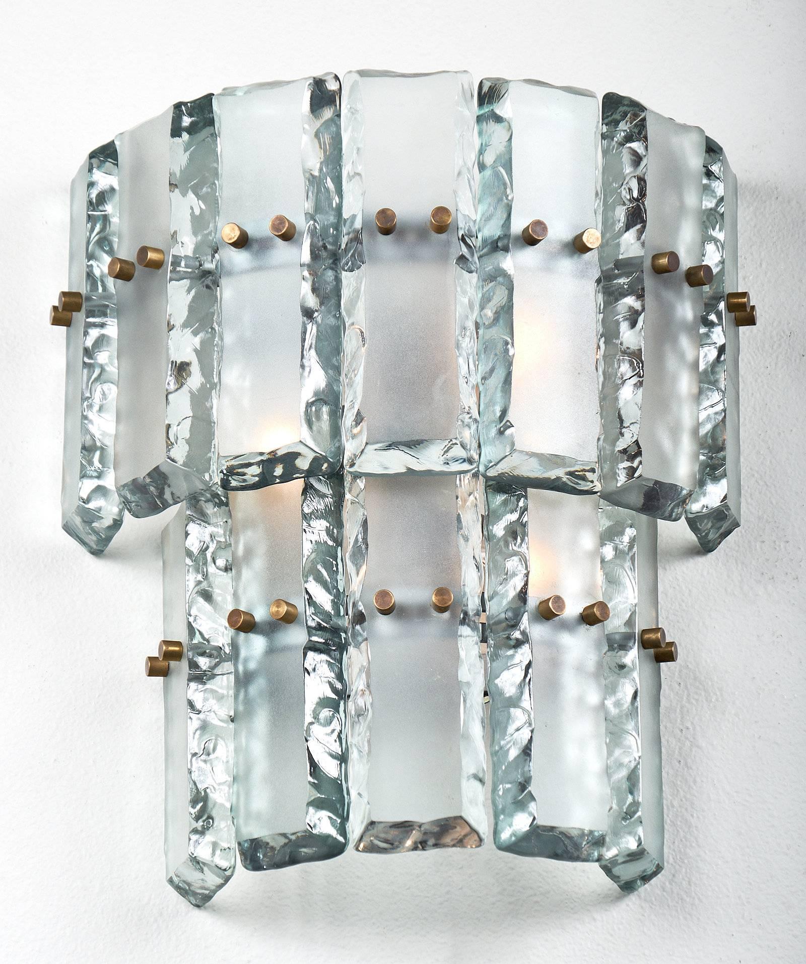 This incredible pair of sconces are made of chunky crystal like slabs of vintage Murano glass in the stye of Fontana Arte, circa 1970. The edges of each piece are polished and uneven, while the fronts of the glass are frosted and smooth. The glass