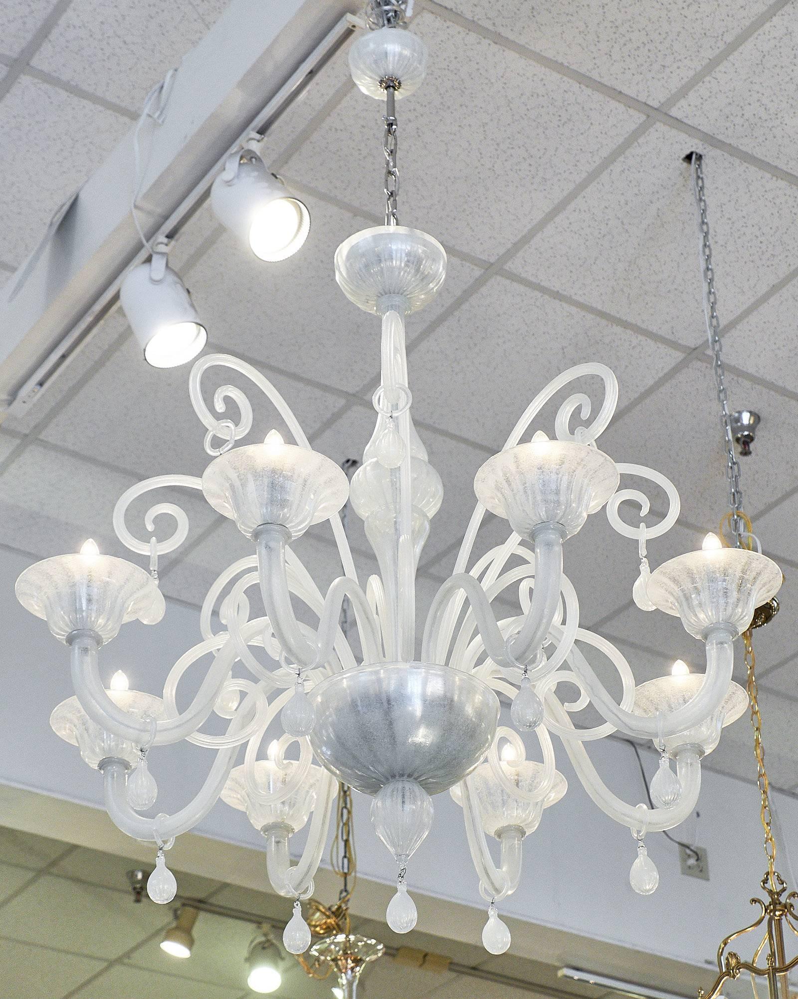 Incredible iridescent Murano glass chandelier with curled glass holding lovely drop pendants. The cupped boboches on each of the eight arms add a traditional quality to the whimsical piece. The handblown glass is stunning as the light reflects off