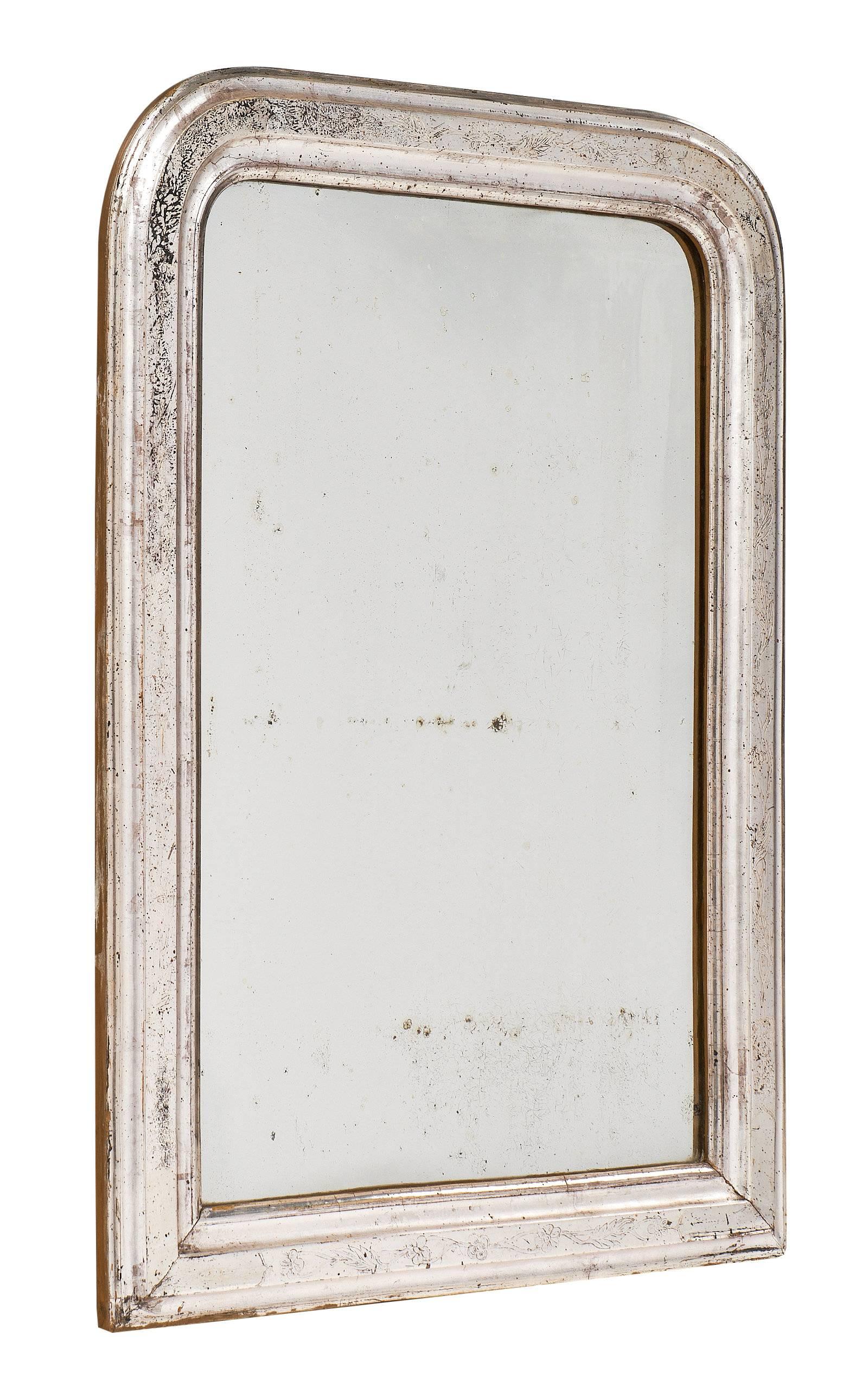 Lovely Louis Philippe mirror with original antique mirror and silver leafed frame. The classic curved upper corners showcase the history of this piece, circa 1845. There is an etched pattern of floral details on the beautiful silver leafed mirror.