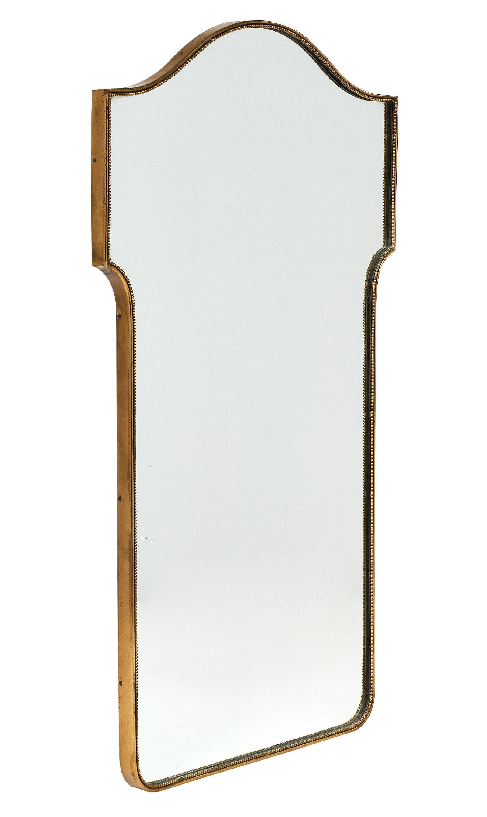 Brass mirror from the midcentury in France with a striking winged shape for a dramatic effect. The frame of the mirror includes brass beading for extra detail. This is a lovely piece in excellent vintage condition.