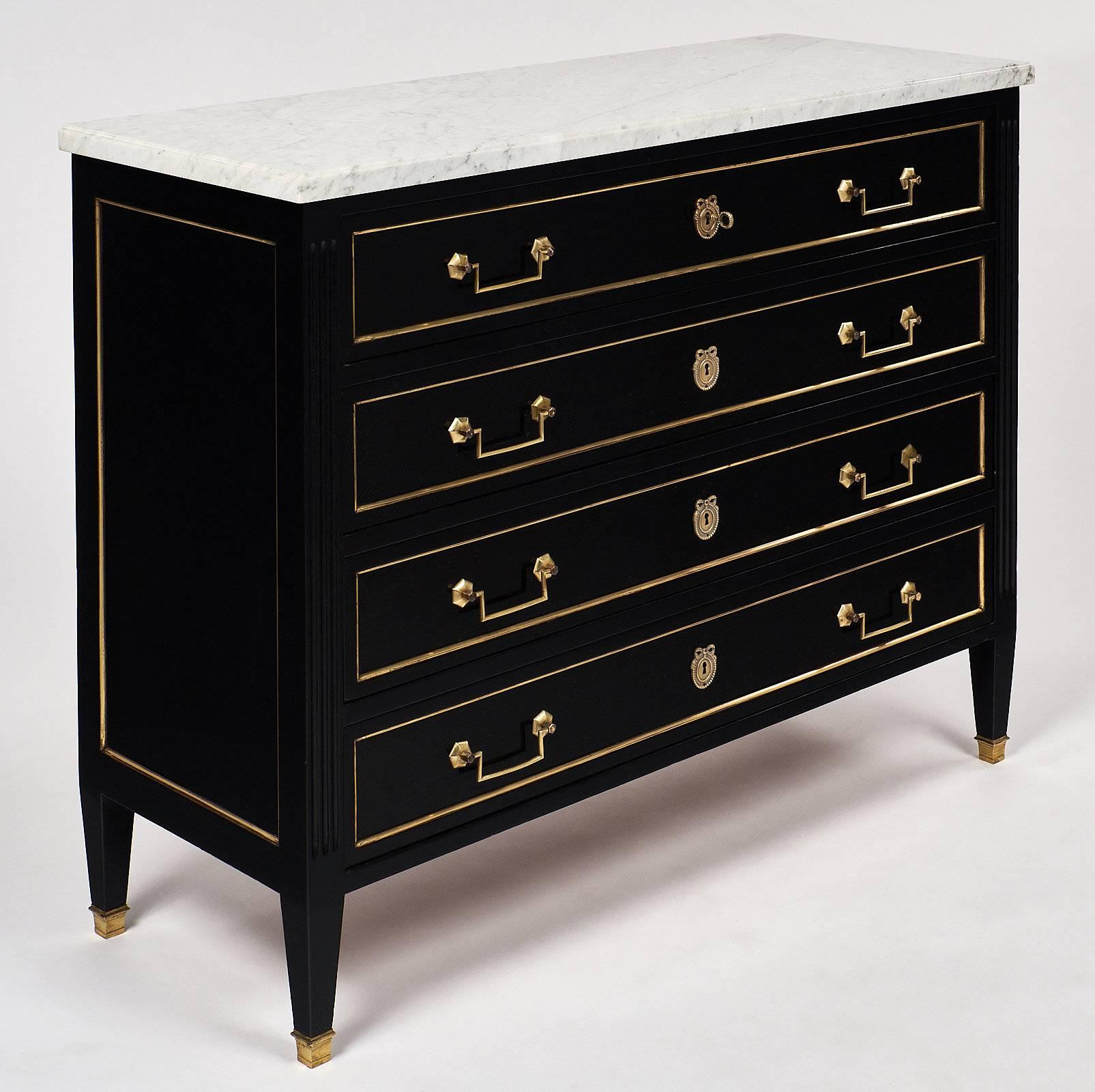 Classic Louis XVI style chest with a beautifully veined Carrara marble top. This chest has been ebonized and finished with a lustrous French polish. There are four drawers, each with brass pulls. There are working locks on all four drawers, with one