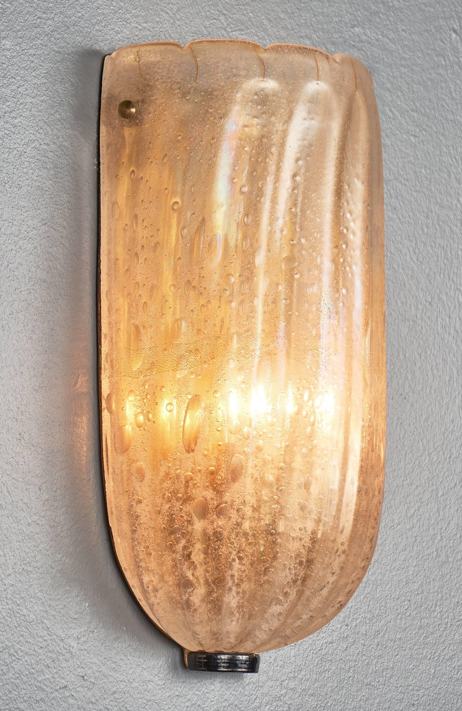 Vintage Italian pair of sconces made of hand blown Murano glass infused with gold flecks for an iridescent effect. Made in the pulegoso technique, air bubbles are formed in the glass, adding texture and depth. We loved the classic look yet organic