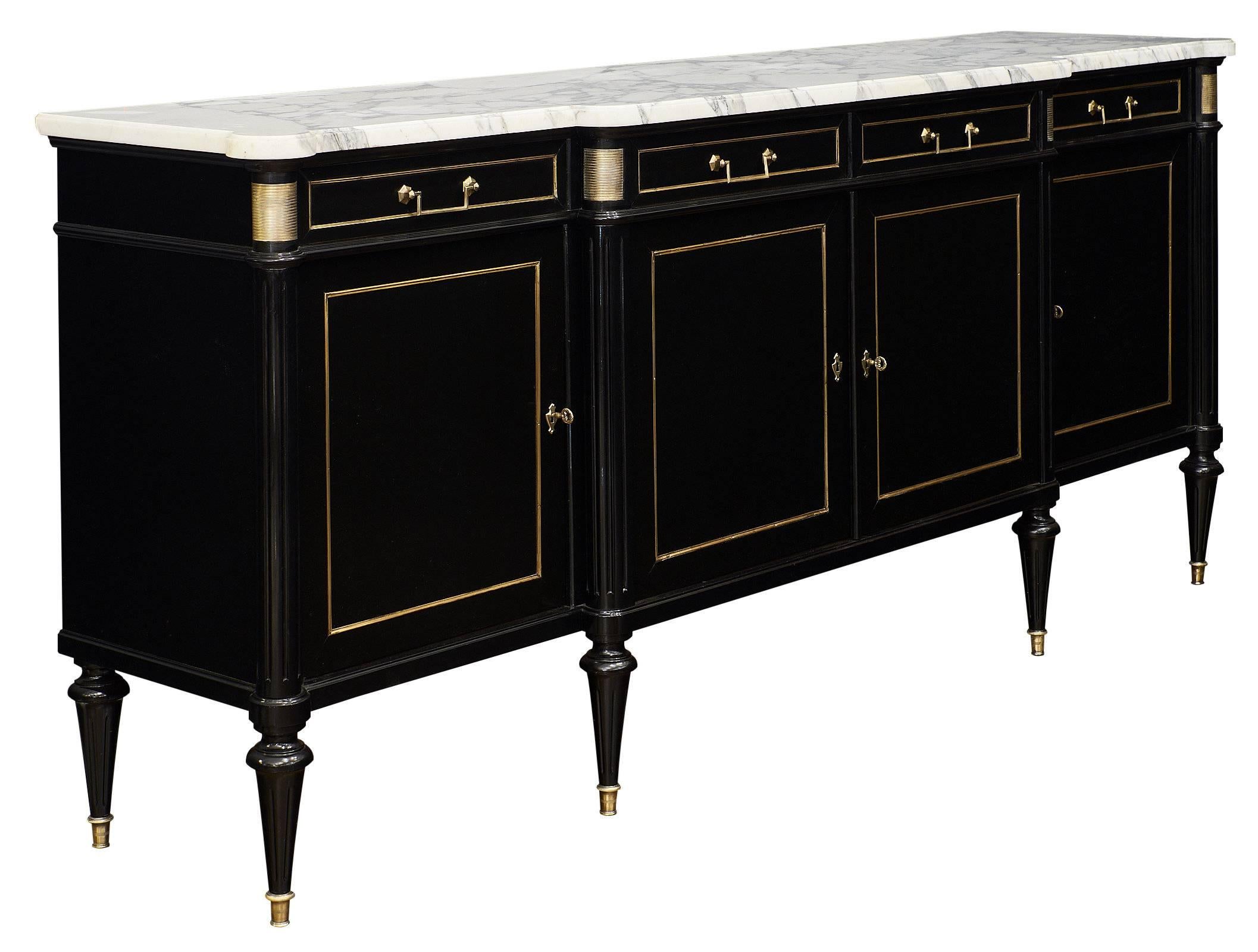 Fantastic Louis XVI style buffet with an impressive size and perfect lines. This piece is made of solid mahogany that has been ebonized and finished with a lustrous French polish. The buffet features an intact Carrara marble slab top. The hardware
