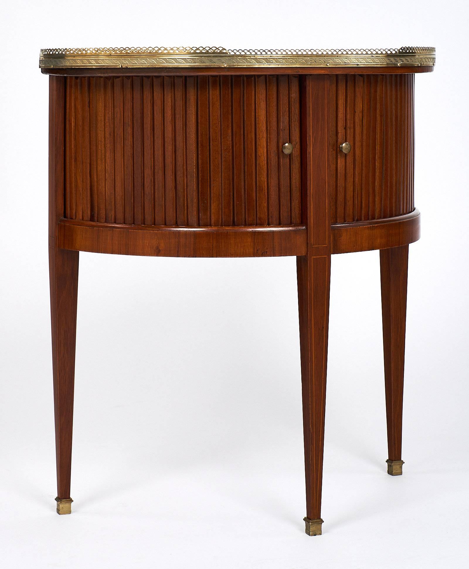 Lovely Louis XVI style demilune made of mahogany and topped with a beautiful “rouge Royal” marble top. The marble has great veining of pinks and grey, and has a brass gallery. All three tapered legs are capped with brass feet. The front panelling