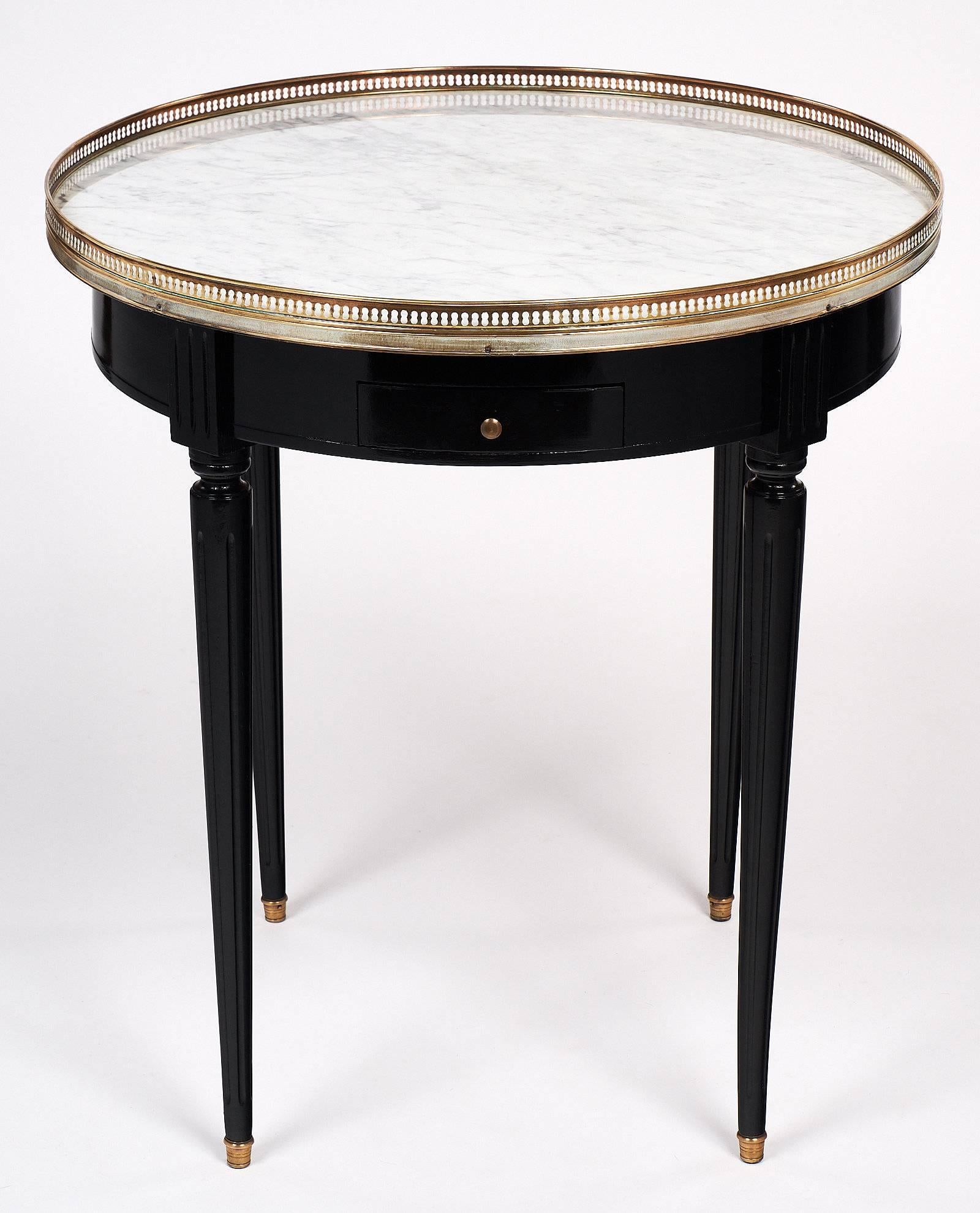 Charming bouillotte table made of solid mahogany that has been ebonized and finished with a French polish for luster. This side table has two drawers and two pull-out tablet shaped leaves. Each leaf adds an additional 7” to the length, and are