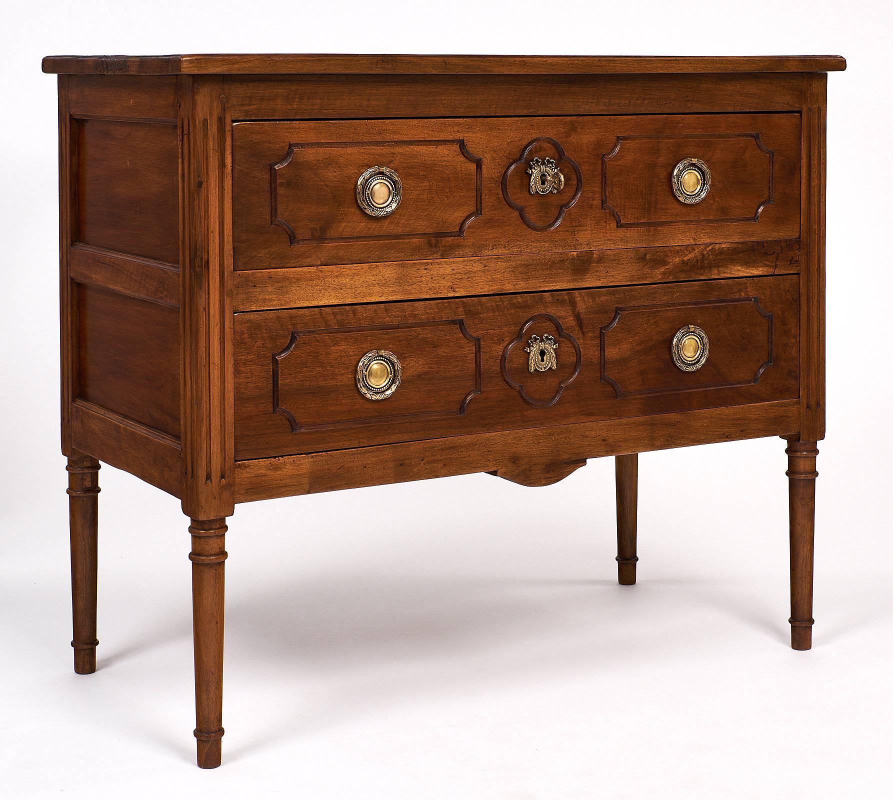 Beautiful chest in the Louis XVI style. The walnut has a warm honey tone and is in excellent condition. The fluting on the sides is hand carved, as well as the classic and elegant carving that surrounds the brass hardware pulls and locks. Both