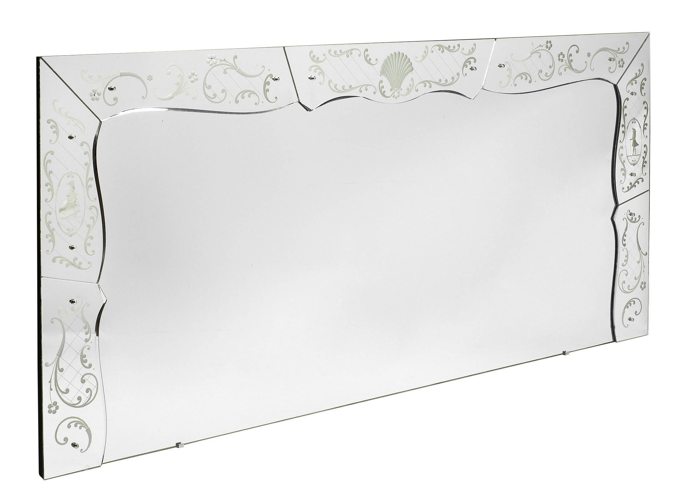 This extra large Venetian mirror from the Art Deco period is stunning in its magnitude and beauty! This marvellous piece has a long rectangular mirror framed by chiselled mirror pieces. There is a lot of ribbon and floral detailing engraved