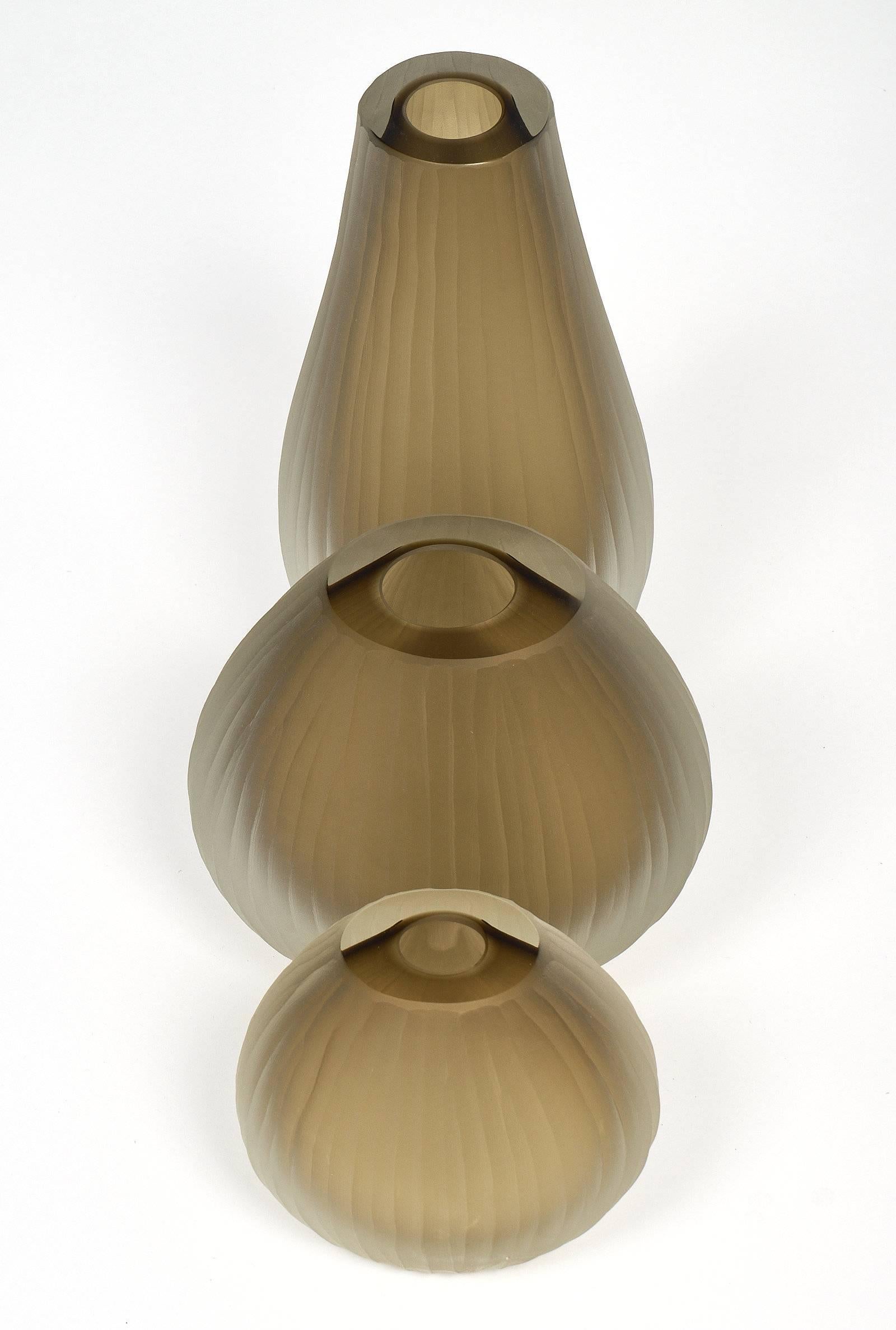 Three handblown Murano glass vases of different sizes executed in the “battuto” or “hammered,” fashion originated by Tobia Scarpa during his time at Venini in a smoke grey color. Each has a lightly textured and frosted finish. Measures: The large