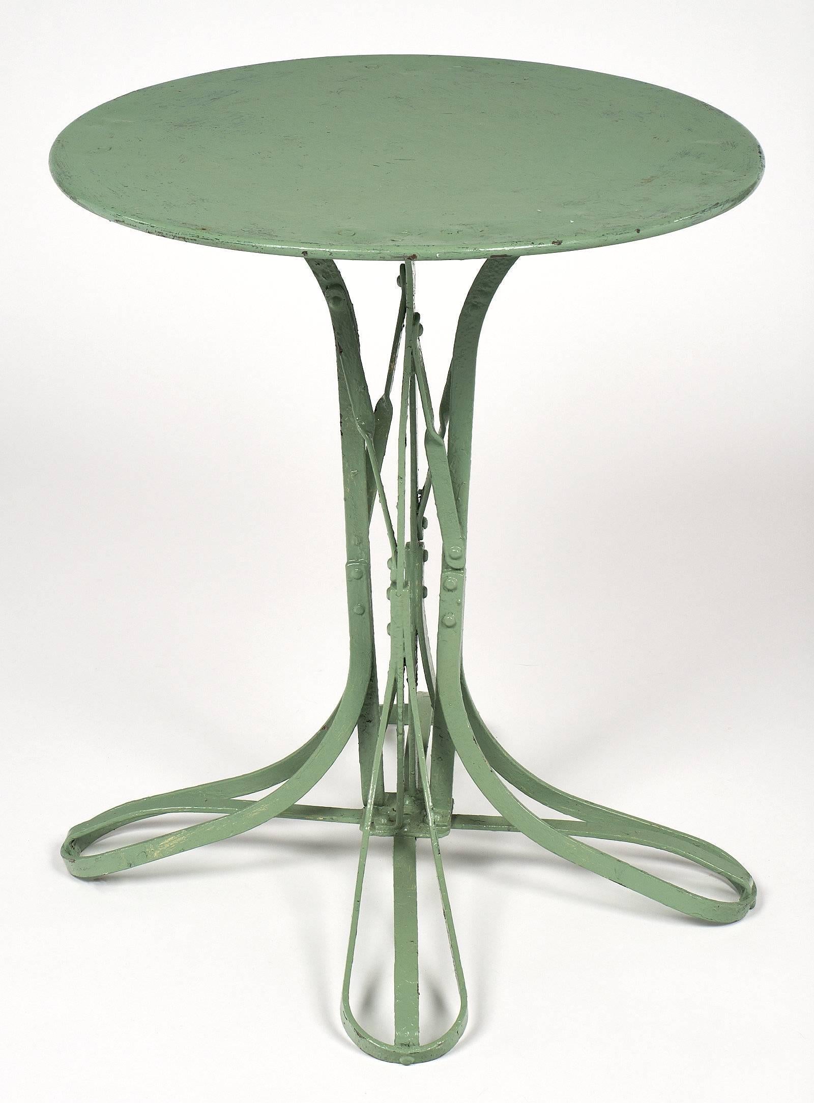 Charming bistro table from France made of iron. The legs are curved around for an organic element, and the piece is painted the original green color. The patina is original as well, and adds a depth a character to the piece.