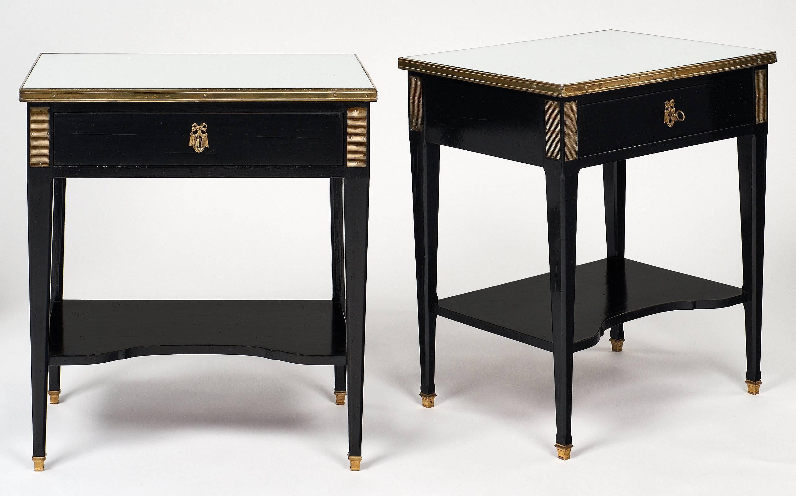 Beautiful Directoire style side tables topped with mirrors. Each table is trimmed with brass and features elegant finely cast brass hardware with working locks and keys. Each tapered leg is capped in brass. We love the great shape and details of