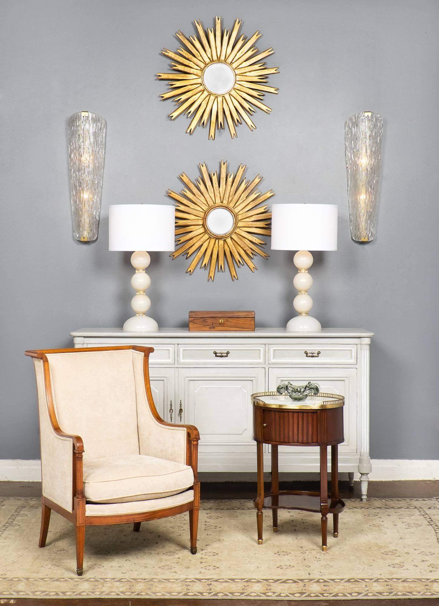 Gorgeous French Directoire style bergère in blonde mahogany with inlays of rosewood, finished with a lustrous French polish. Professionally reupholstered in a beige chenille velvet. A beautiful conversation chair that is comfortable as well.