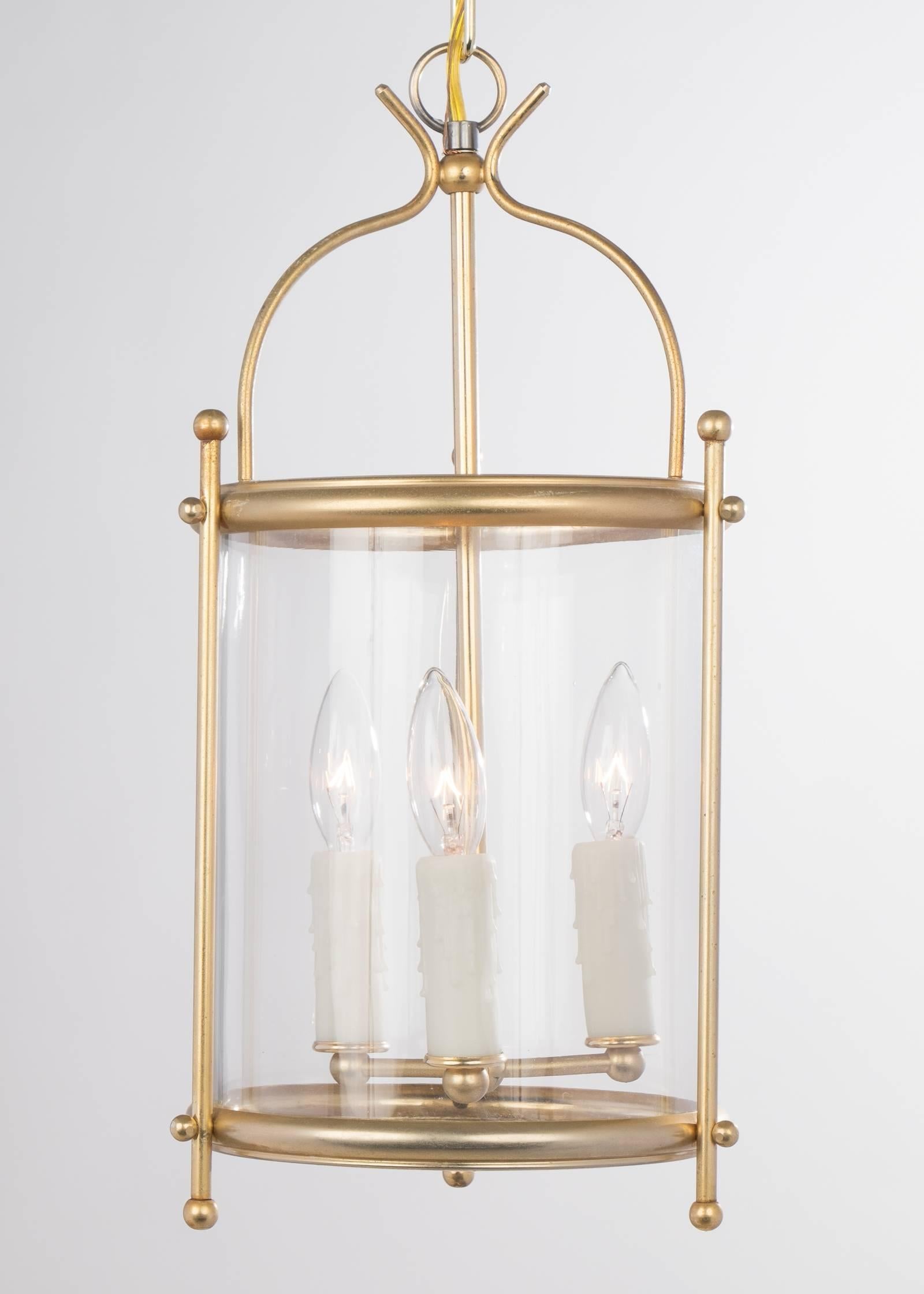 French vintage pair of brass and glass lanterns, each electrified with a three candelabrum cluster, rewired for the US. Height with included chain and canopy is 38.75 in.