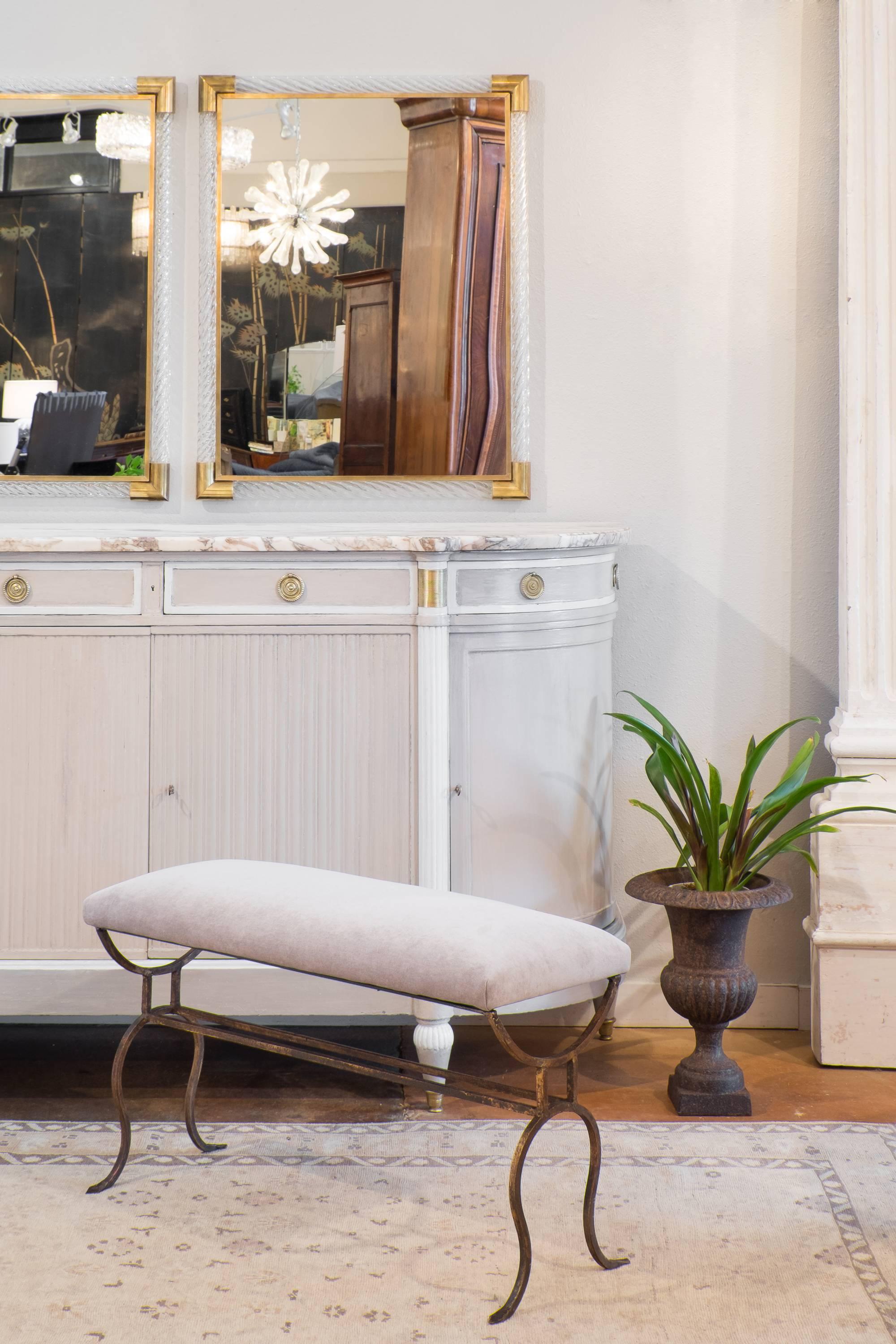 Antique Spanish gilt forged iron bench, professionally reupholstered in a dove gray velvet blend. Very strong and sturdy, we love the open, curving frame. These are a great example of the beautiful hammered and gold leafed iron works created in