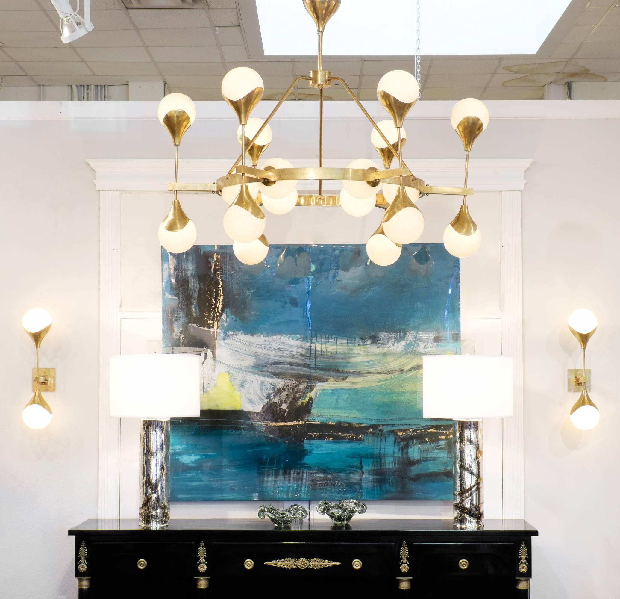 Italian pair of Mid-Century Modern style sconces in brass with pearl translucent glass shades. These wall sconces are a statement piece, radiating beauty on or off. Each sconce requires two candelabra-base bulbs, and is wired to fit US standards.