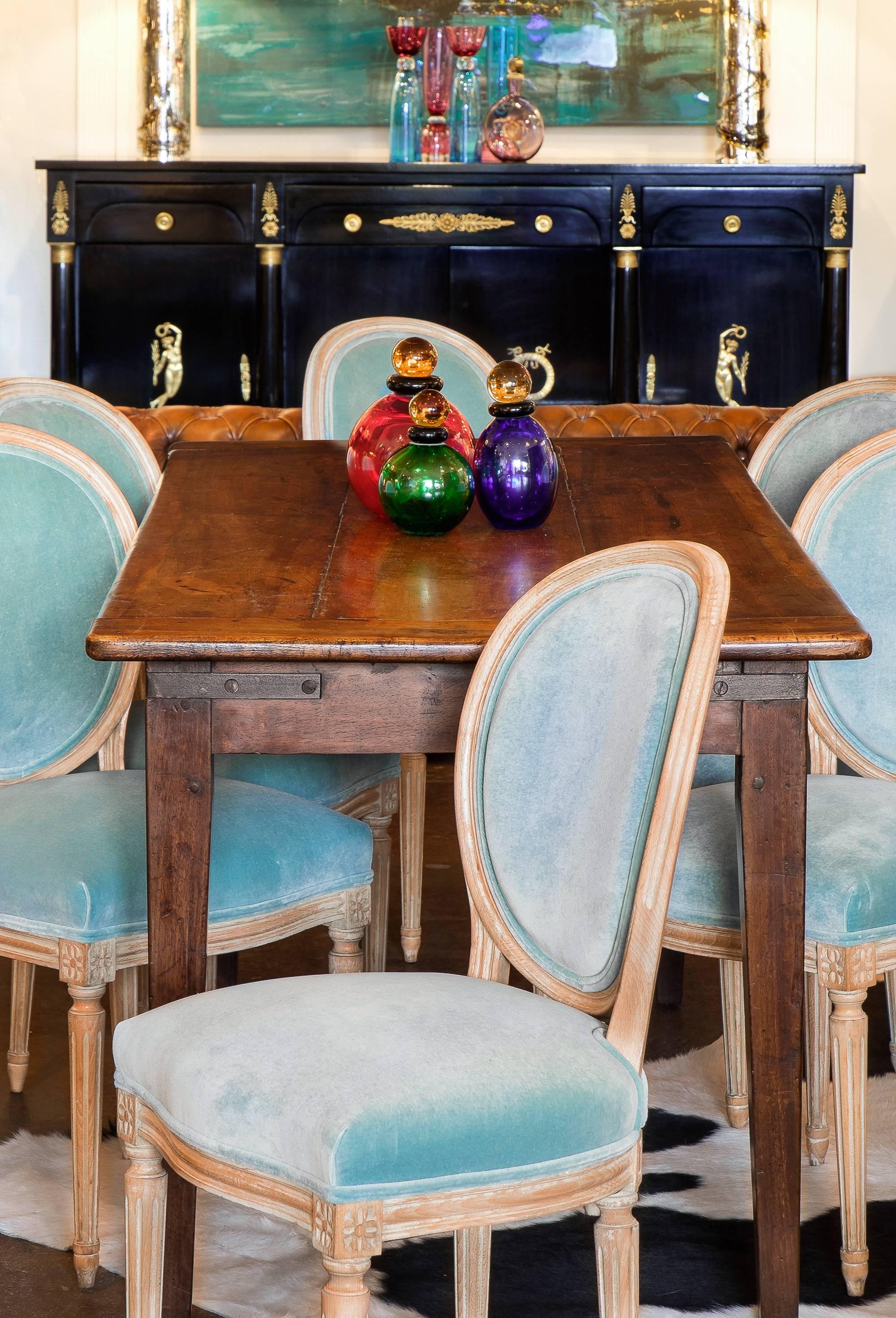 French antique set of six Louis XVI style medallion back dining room chairs. Solid beechwood frames with carved fluting and floral details, tapered legs. The original paint finish has been striped to reveal the wood grain; some of the pigment remain