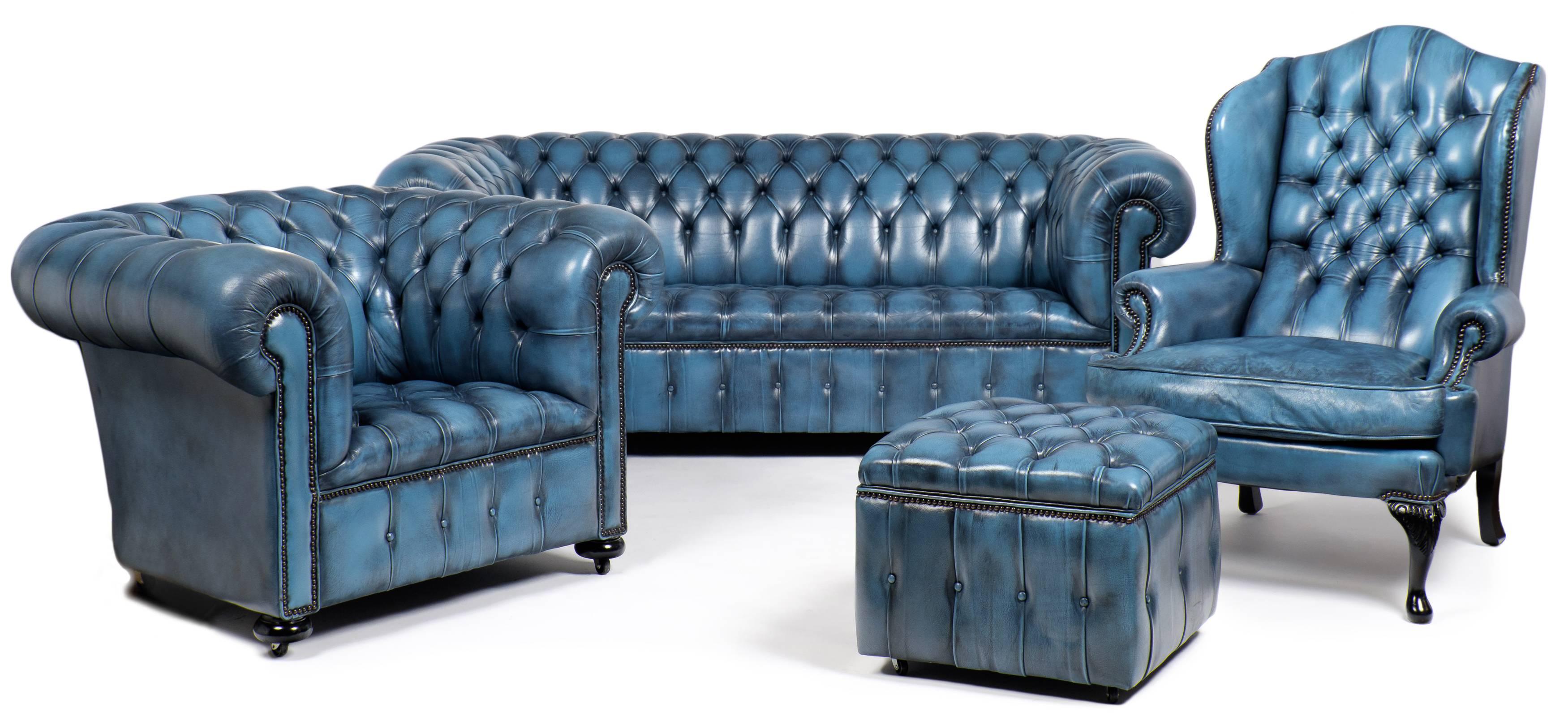 English vintage Chesterfield ottoman in steel blue tufted leather upholstery with bronze nailheads, on casters. Rich in character, the top of this stool hinges open for easy access to a large storage space.

See the matching Chesterfield sofa,