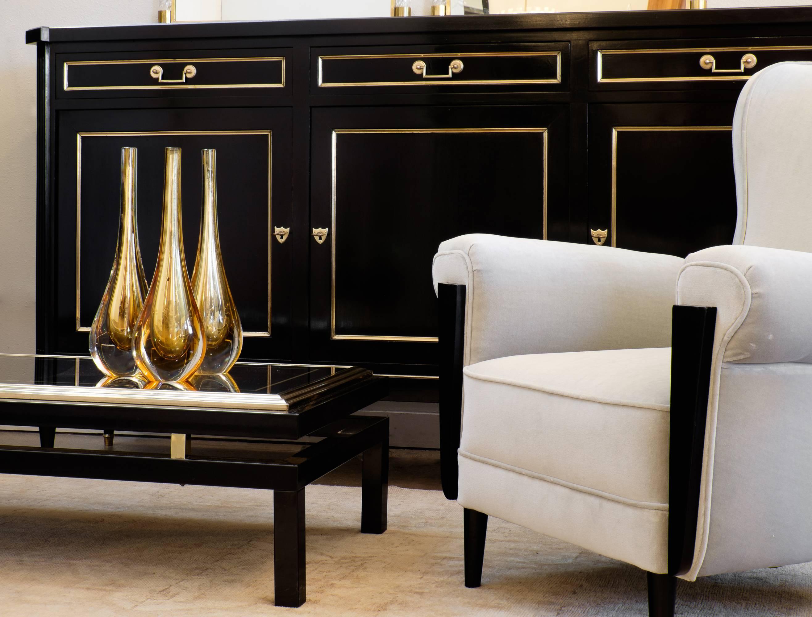 French antique, Louis XVI style sideboard in solid mahogany, ebonized with a lustrous French polish finish, fluted legs, trimmed in brass. Three dovetailed drawers and three locking doors with adjustable interior shelves.