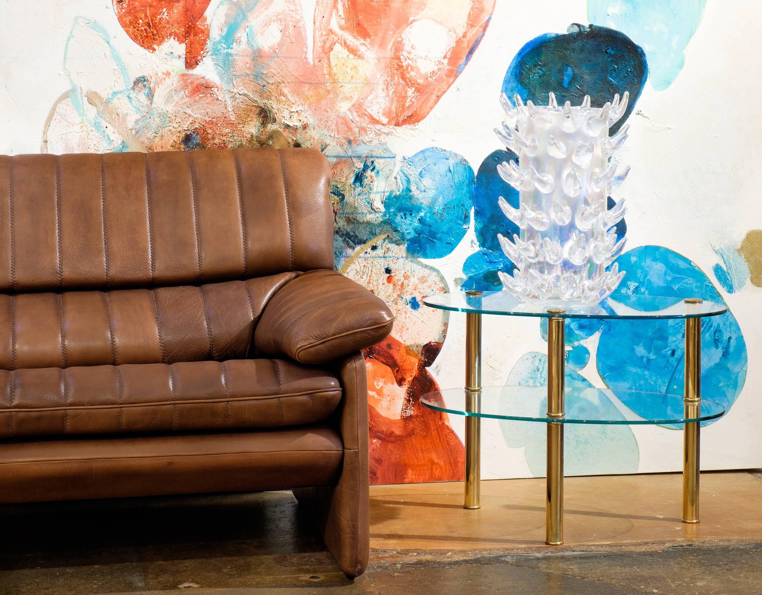 An ultra sleek vintage de sede DS-85 soft leather sofa in a sepia brown. This Swiss piece from the 1970s is undeniably comfortable cushioned by a vertical patchwork of leather. Measures: Seat height measures 19 inches. Look at the matching armchair