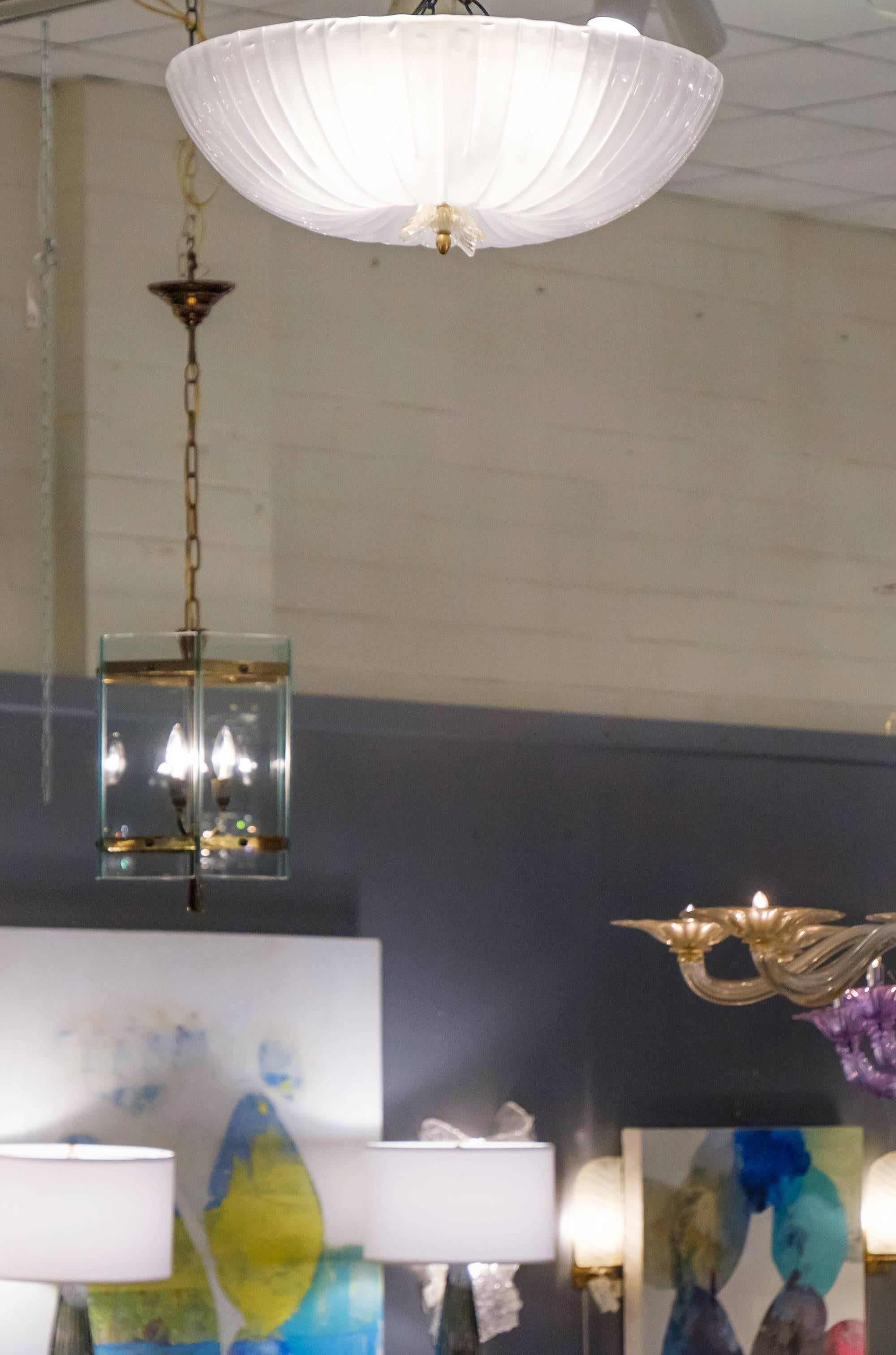 A gorgeous piece handblown in Italy, this Murano glass fluted dome flush mount ceiling fixture has a lovely 23-karat finial detail at the centre. When lit, the light provides a soft ambient, exceptional glow that is distributed evenly throughout the