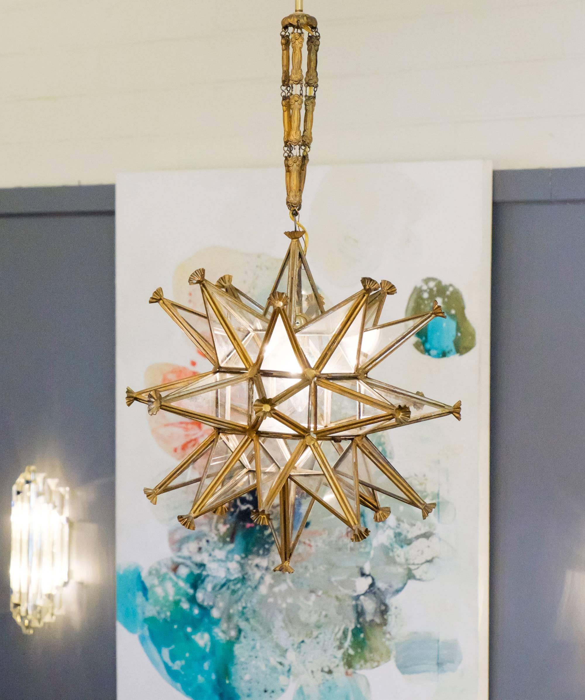 A beacon of glowing starry light, this French Art Deco period gold leafed metal star chandelier creates a warm, soft, and nostalgic atmosphere. Suspended by an ornate antique chain and canopy. Rewired for the US market.