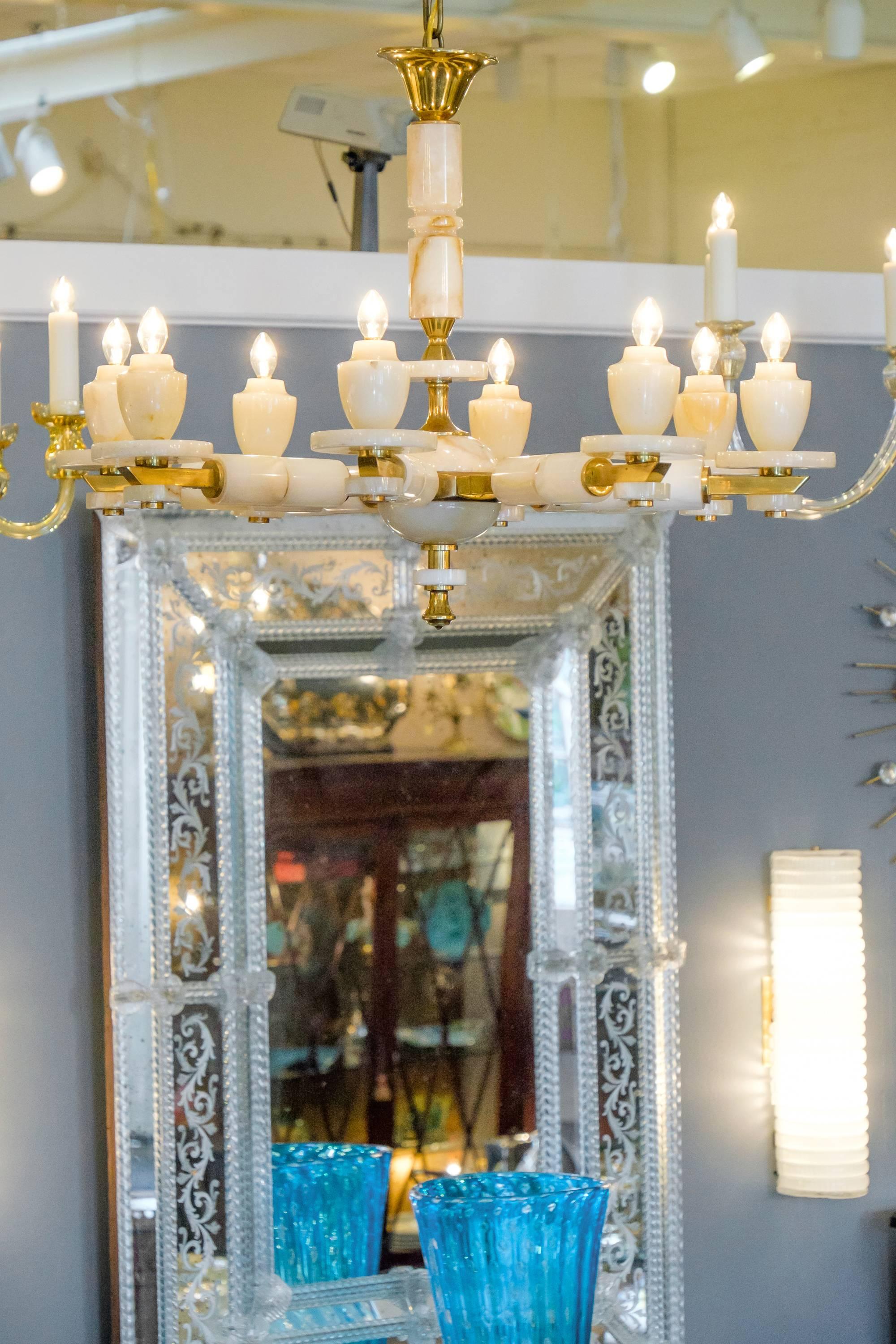 A beautiful vintage onyx and brass chandelier with eight arms. A timeless piece that creates a stunning balance of materials with a combination of metal and stone. Rewired from the US market, this beautiful lighting piece takes eight candelabra base