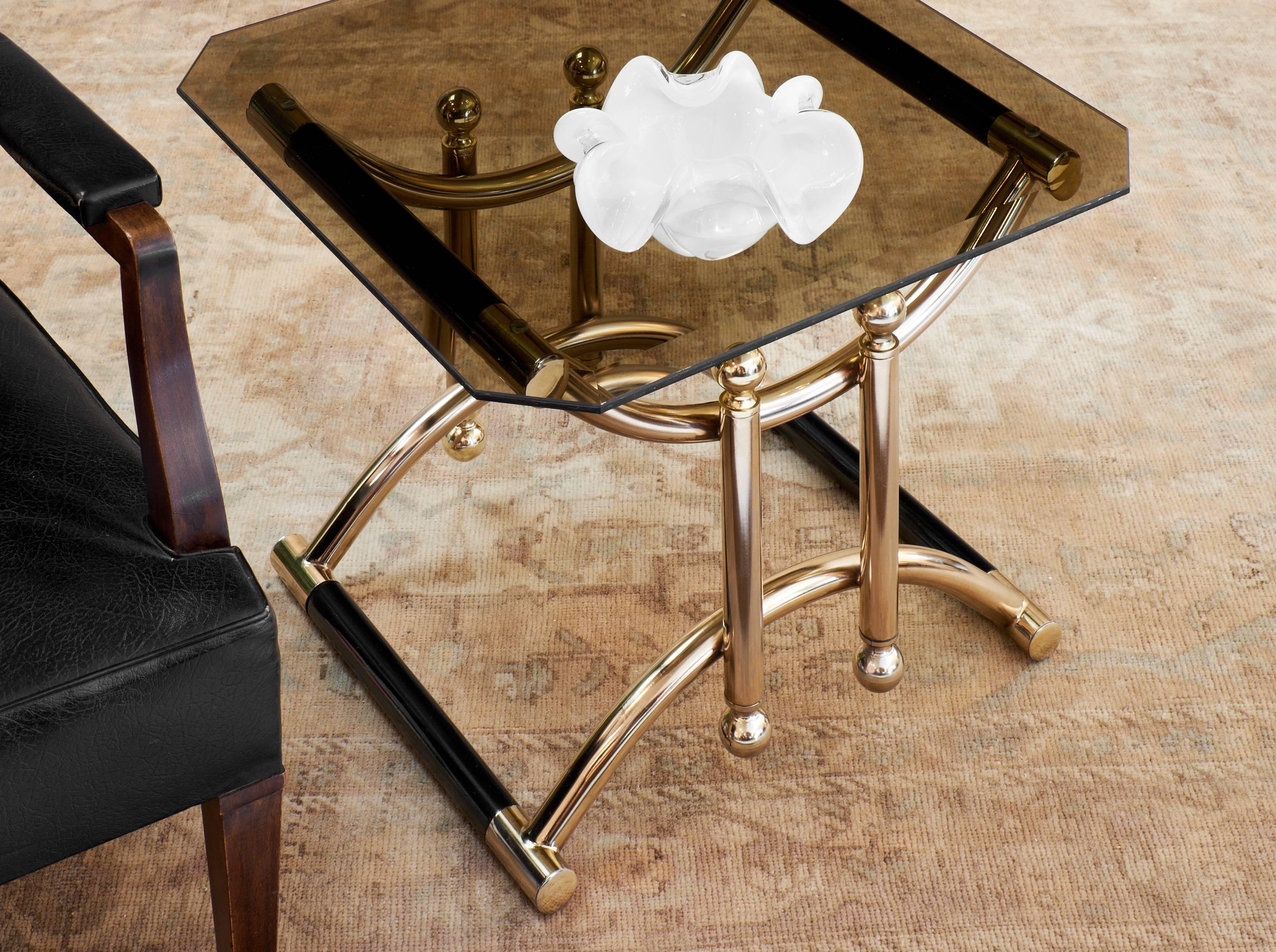 Pair of French Mid-Century smoked glass topped side tables. Gilt brass and ebonized wood frame. Lots of character, bold lines and flawless craftsmanship for this pair by the iconic Parisian fashion house.