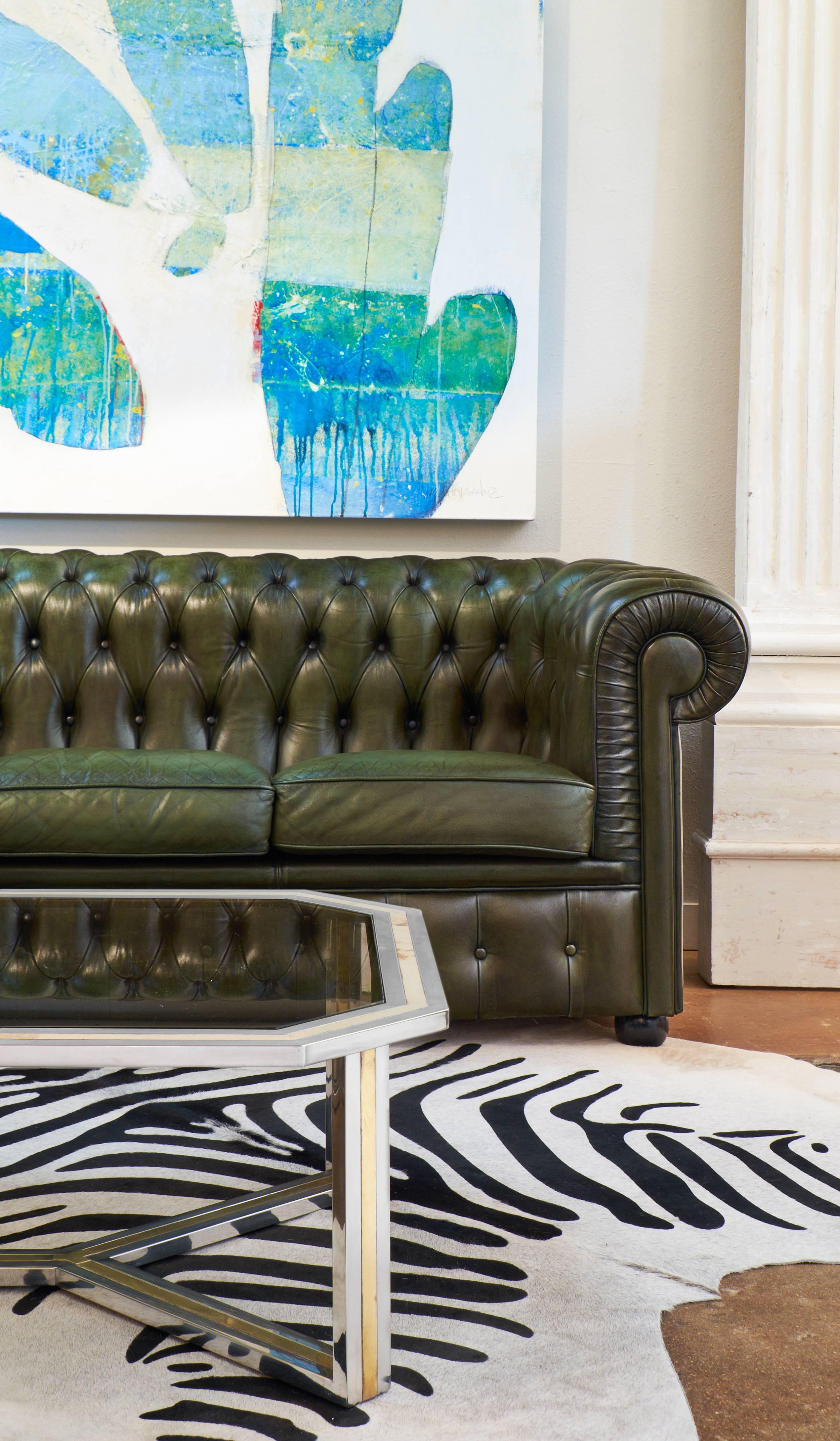 Vintage English Chesterfield sofa in green or bronze color with lustrous and soft tufted leather upholstery. We loved the beautiful color of the leather, the perfect proportions of the piece and above it all its comfort.