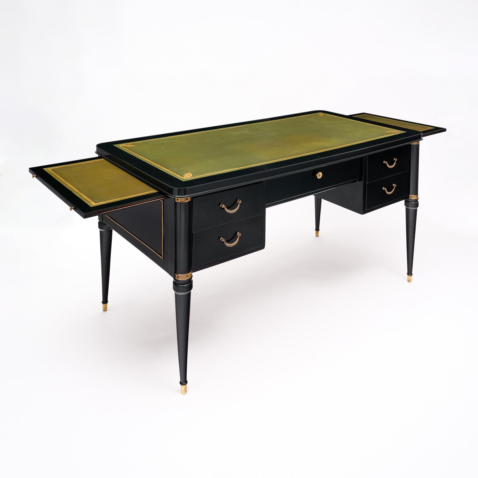 Scrivania francese in stile Luigi XVI in mogano, rifinita con una lucidatura francese di qualità museale. La scrivania è impreziosita da finiture in ottone dorato e da gambe affusolate con piedi in bronzo dorato. Cinque cassetti a coda di rondine,