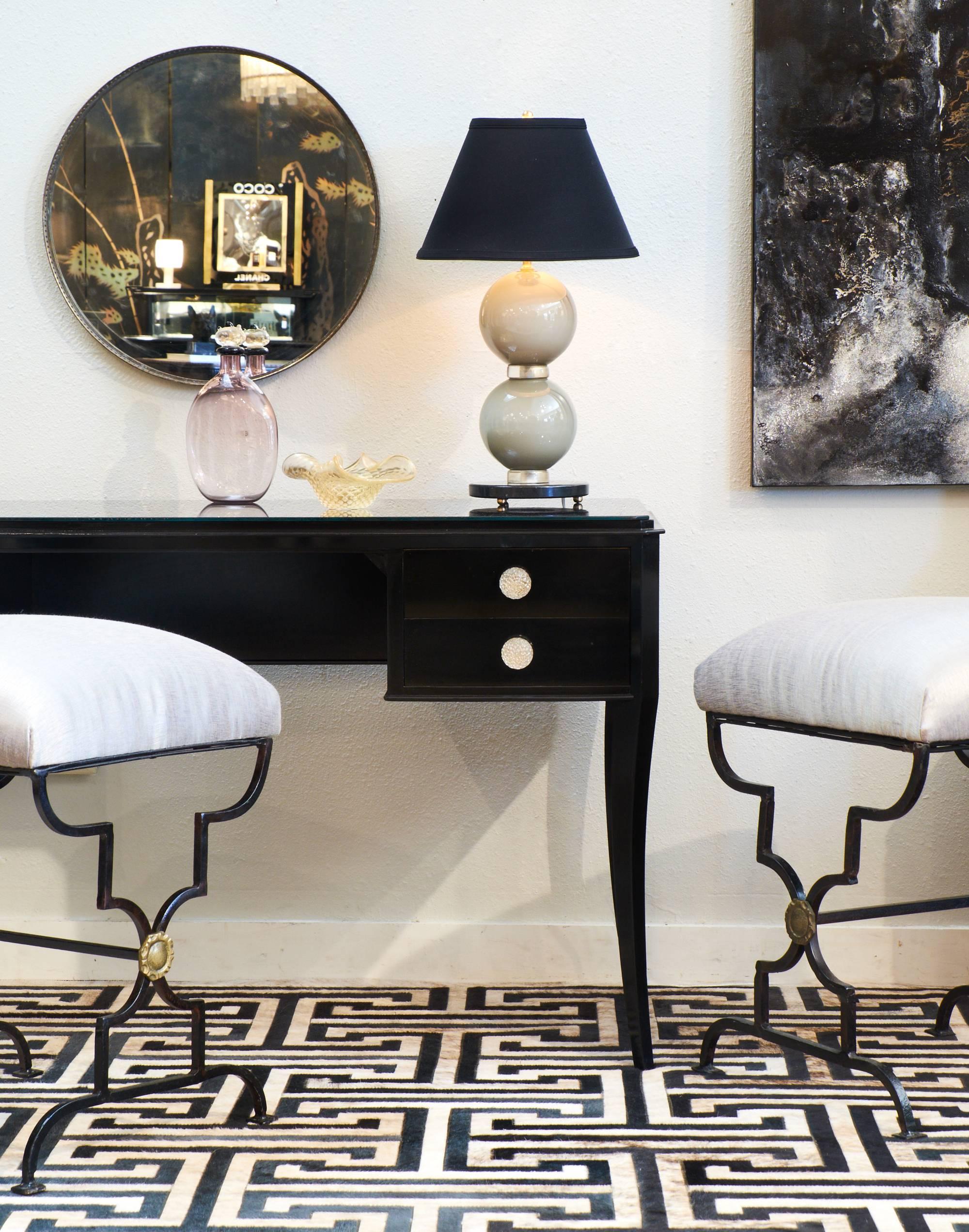 Elegant French Art Deco period vanity or desk of ebonized fruitwood, finished on all sides with a lustrous French polish. A glass top, perfectly fitted, protects the top and makes it an ideal surface for every day use. Four dovetailed drawers with