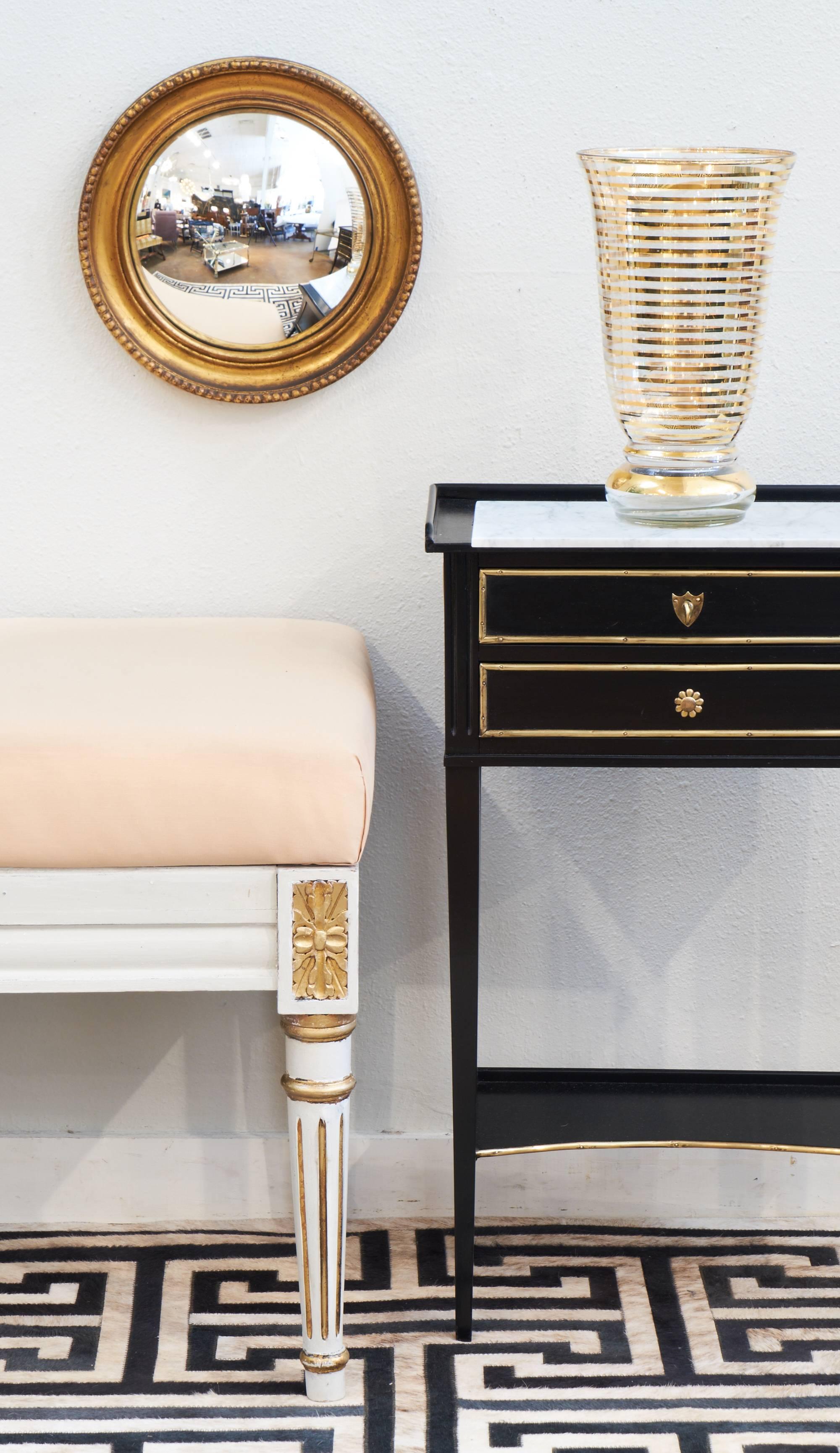 Charming antique French Louis XVI style side table with a white marble top and brass trim. Two dovetailed drawers and a curved shelf connected by tapered legs. A hand-rubbed French polish sets of the flawless ebonized finish on solid wood.