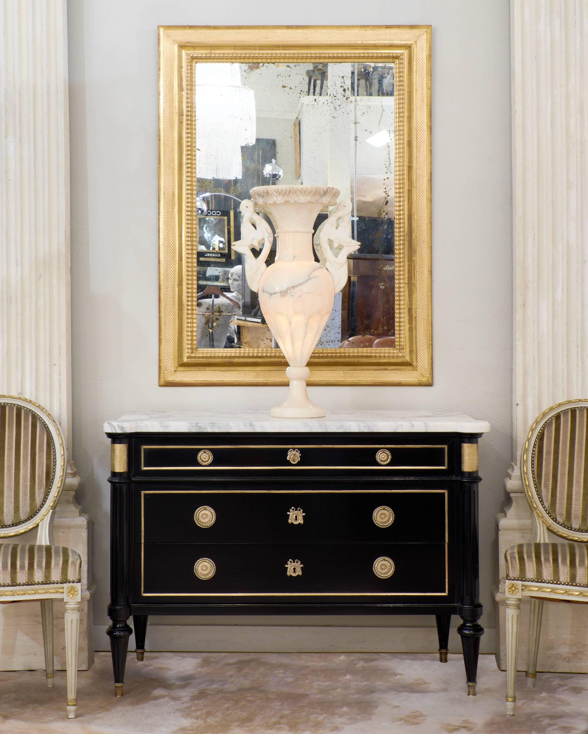 French antique Louis XVI style commode of ebonized mahogany with a hand-rubbed French polish. This traditional finish used in France for museum-quality pieces gives this stately chest of drawers a deep, lustrous finish. Original Carrara marble slab,