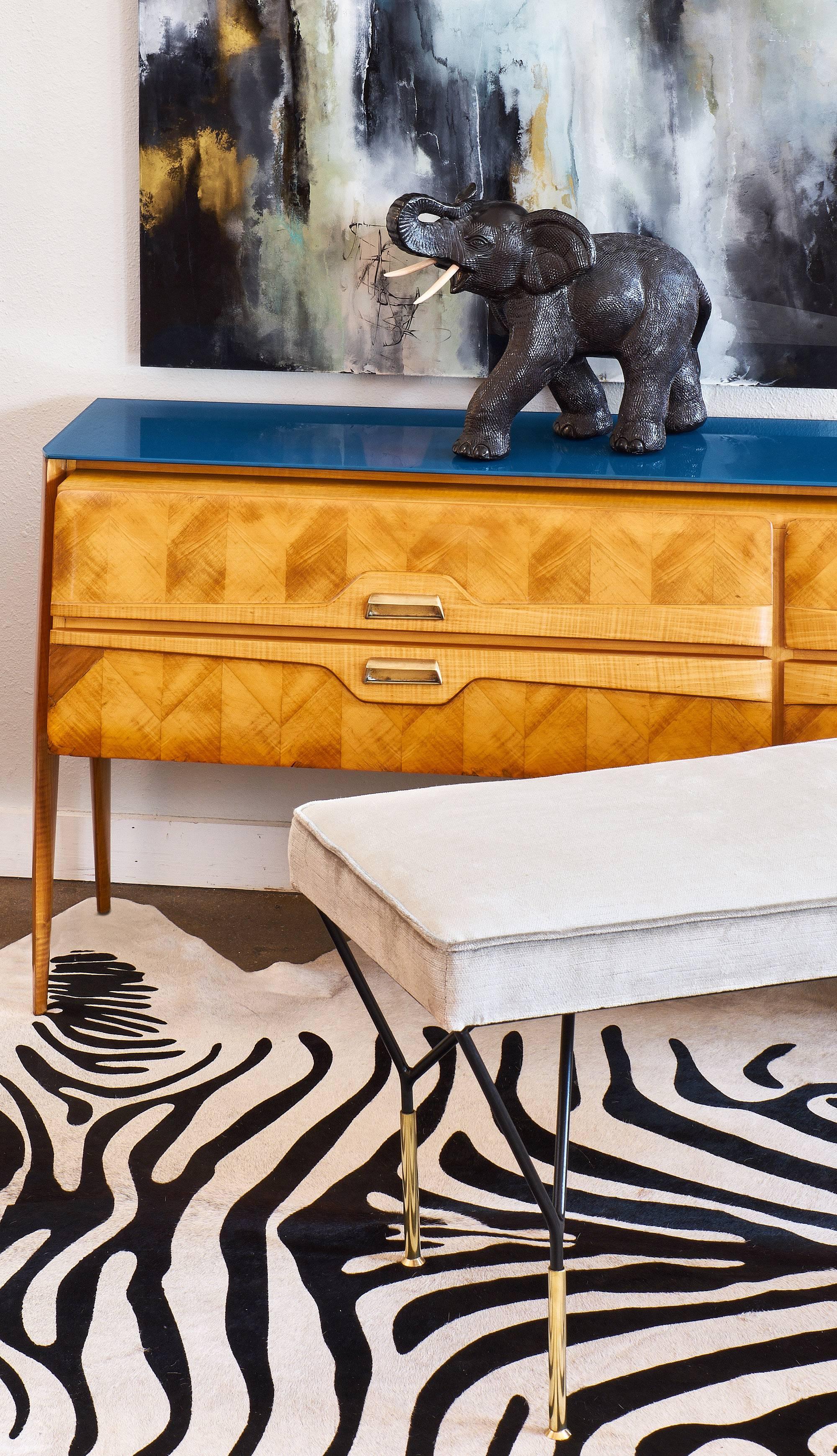 Mid-Century bench by Carlo di Carli. This dynamic bench features gilt brass feet on a black lacquered steel base. It is upholstered in a velvet blend.
 