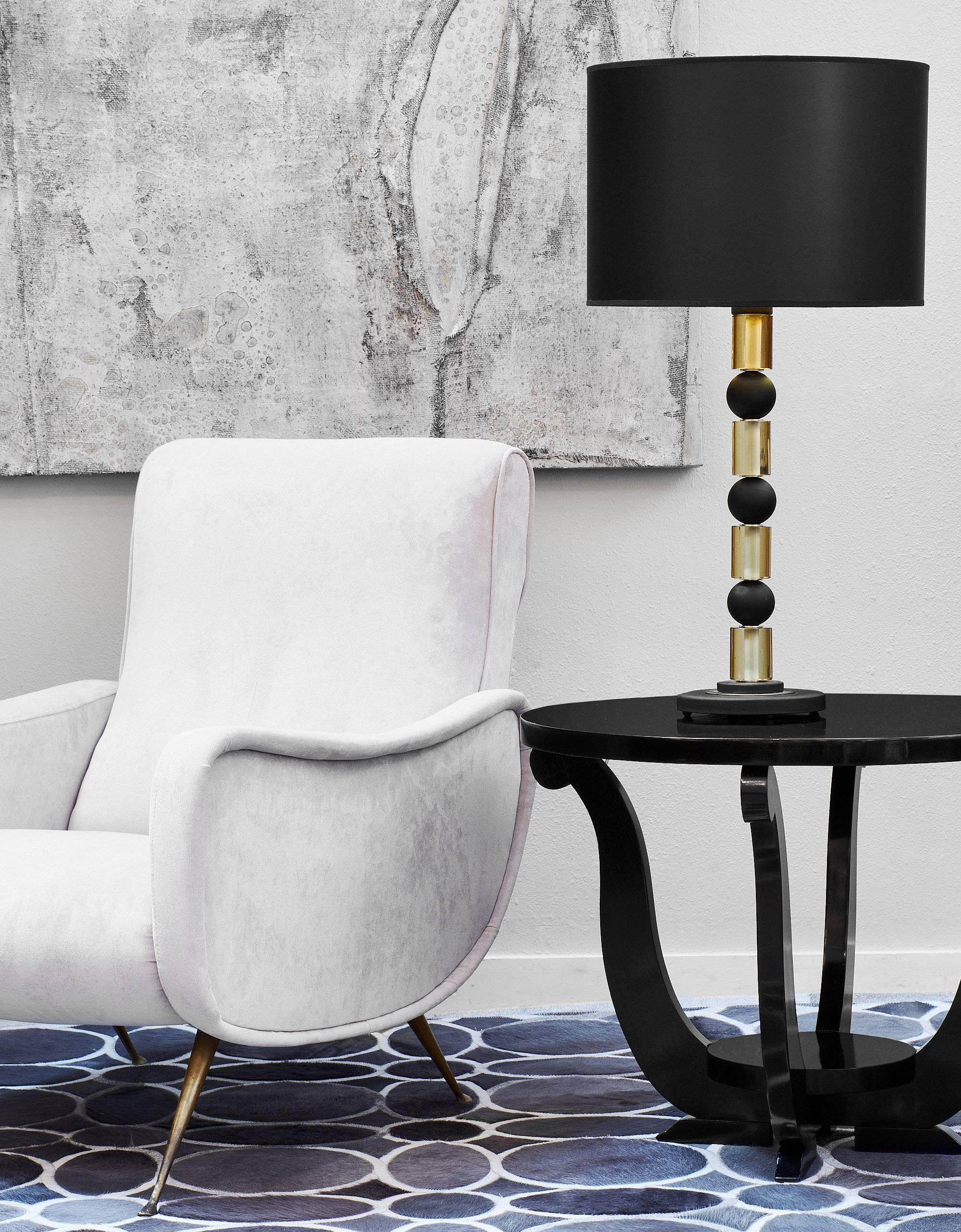 These sleek and modern Murano glass table lamps have alternating solid black spheres with amber gold glass cylinders. The beautiful pair have thick round glass bases and show a very high quality of craftsmanship. The geometric shapes are dynamic and