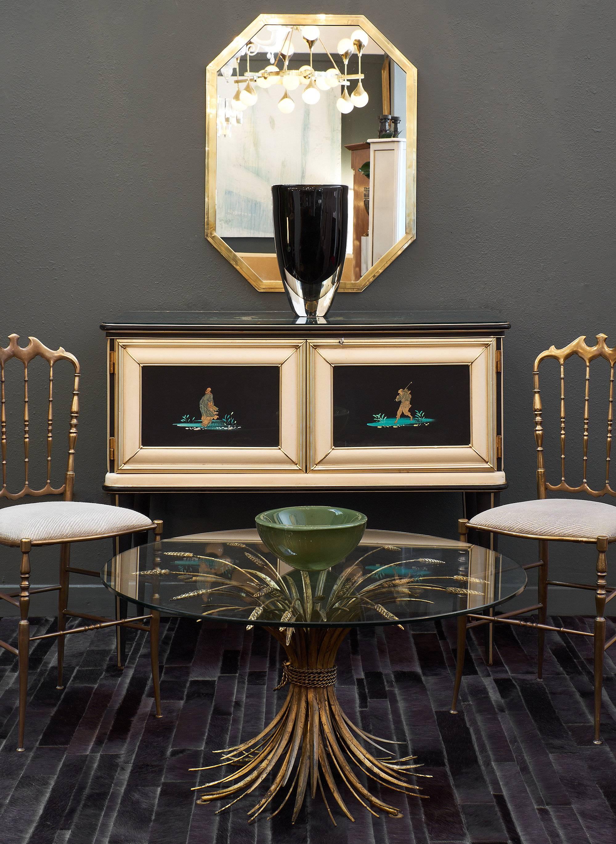 An iconic Italian midcentury chinoiserie sideboard by designer Umberto Mascagni. Black glass panels decorated with teal and gold chinoiserie designs seem to glow on the top and inset into two locking doors. The anodized aluminum frame is covered in