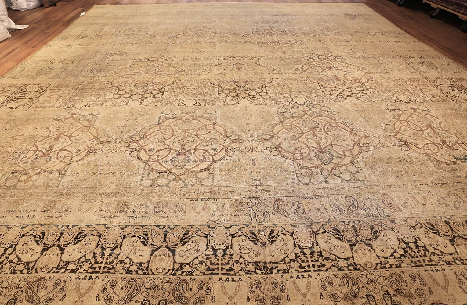 Antique Kerman Carpet, Persia, 1900 -- Beautiful in its carefully interconnected, arabesque elements and hues, this Kerman carpet features characteristic medallions throughout its luxurious ivory field. Despite its impressive size, the artistic