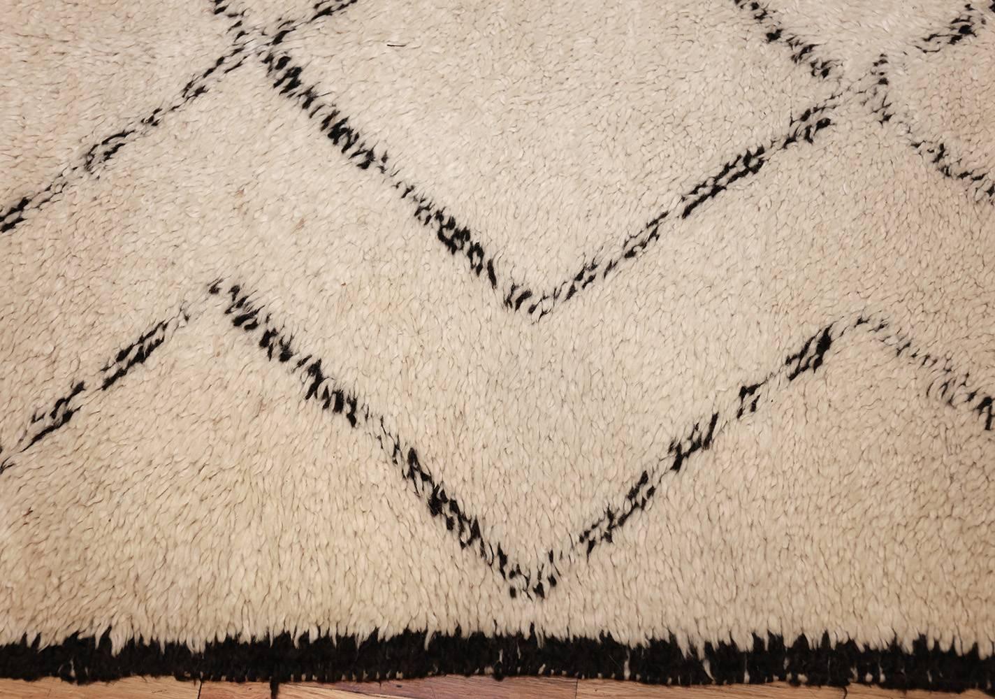 This striking classically Moroccan carpet displays a sumptuous ivory ground emblazoned with simplistic linear decorations that create a strong repeating pattern. Like the sophisticated Berber carpets beloved by designers throughout the 20th century,