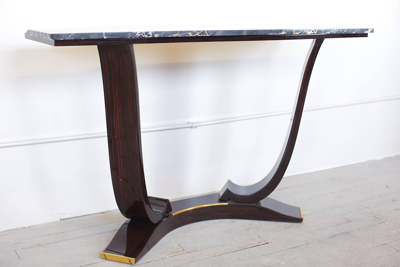 French Art Deco Macassar ebony console table with brass details on the base and a marble top.