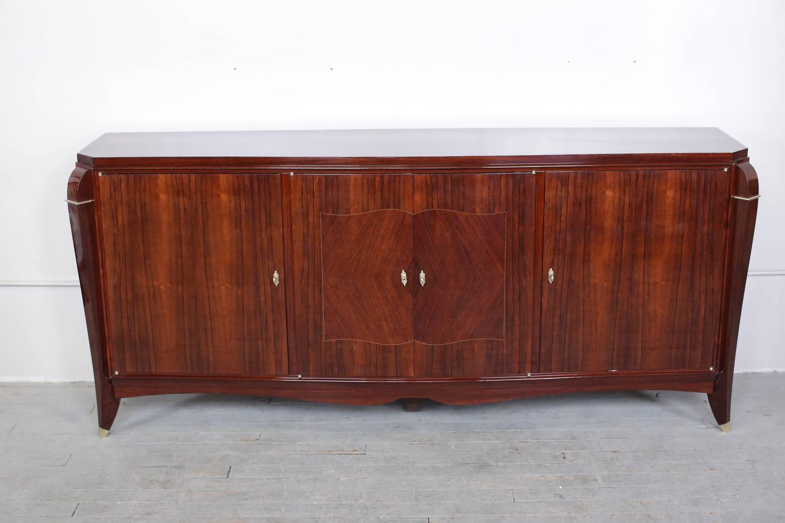 French Art Deco Rio Palissandre sideboard or credenza. Original bronze hardware. Bookmatched inlay doors open to reveal ample storage shelves and two internal drawers.