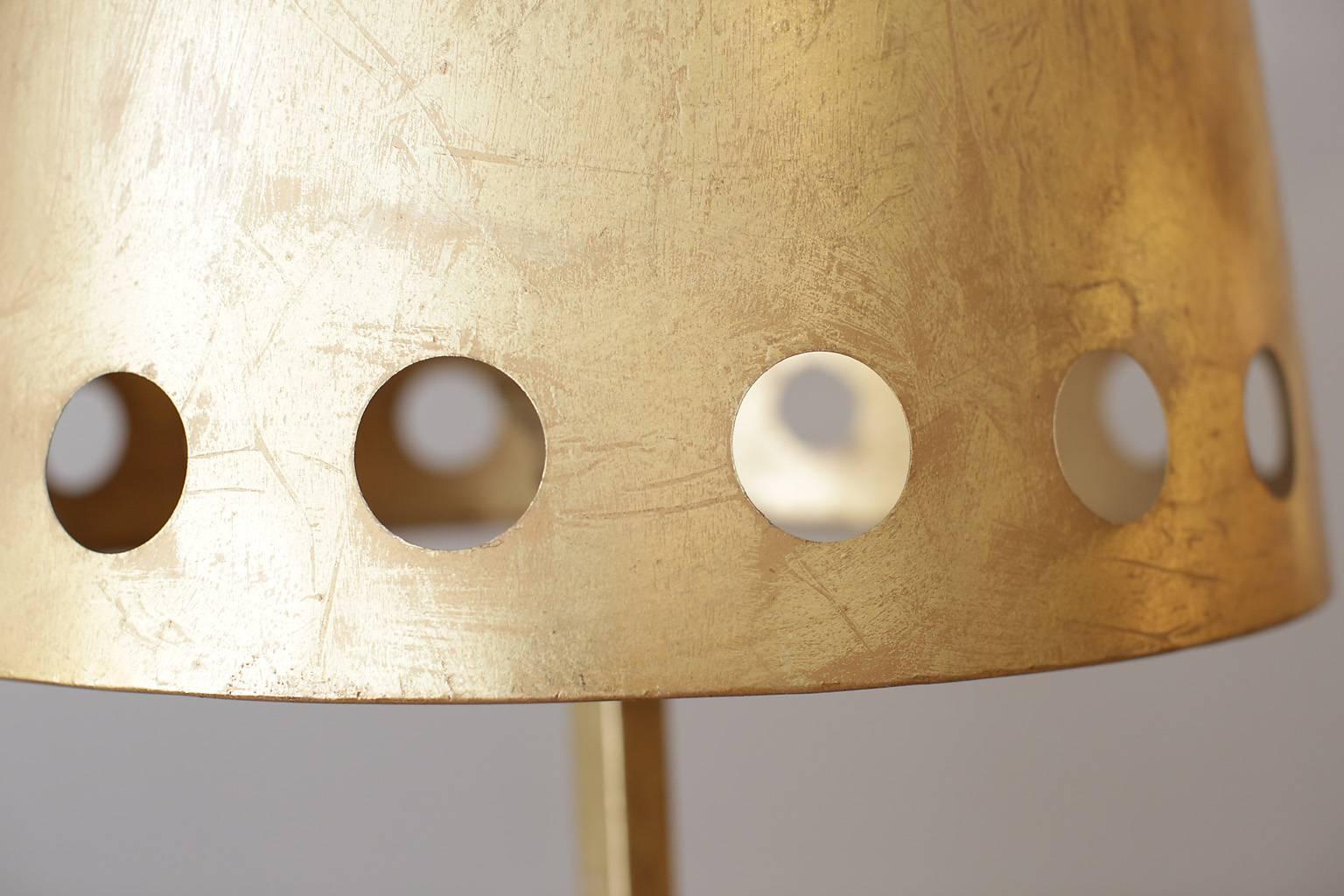 Gold leafed metal floor lamp with metal shade.