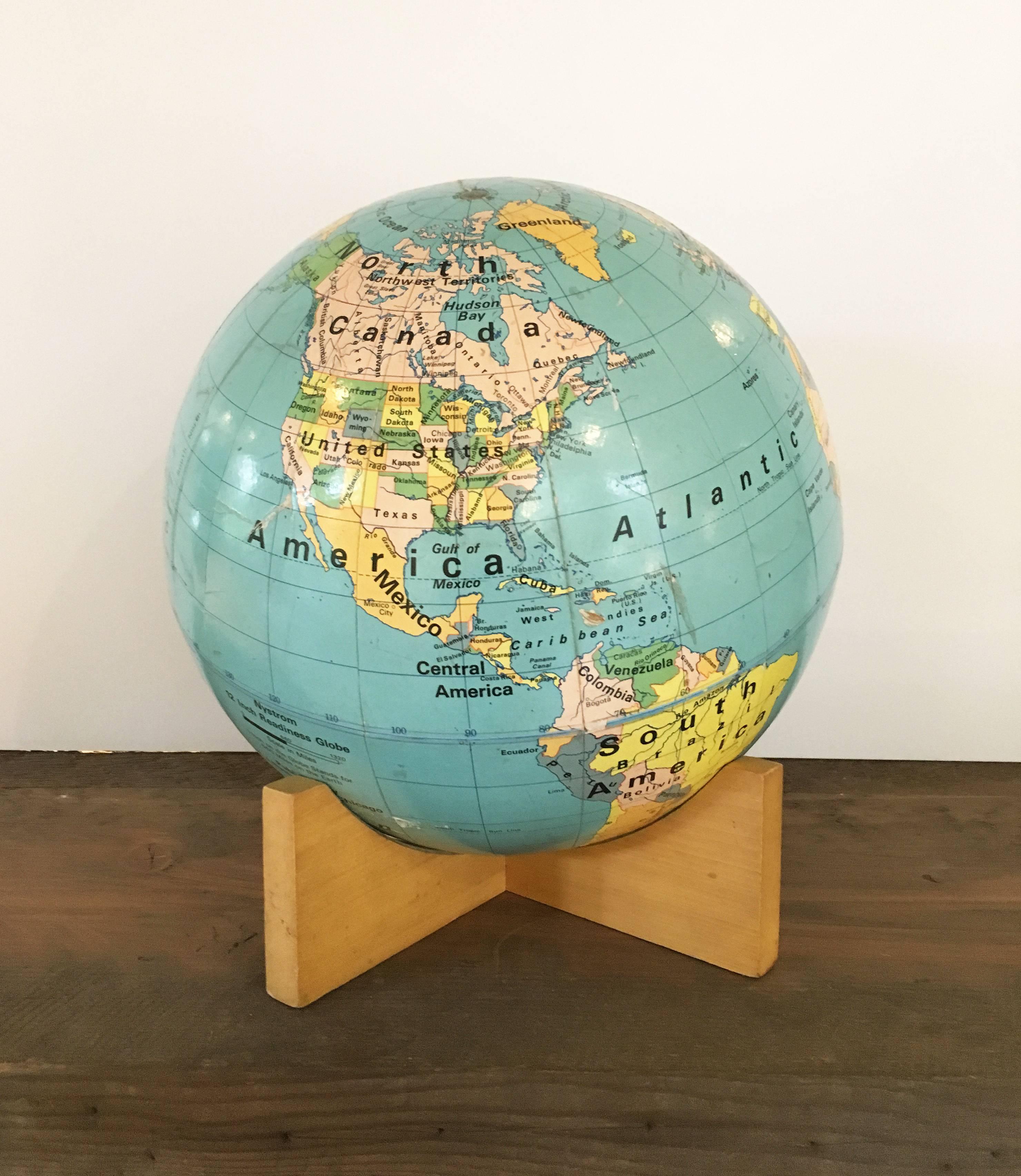 Vintage 12-inch globe from Chicago-based Nystrom on wooden base. 