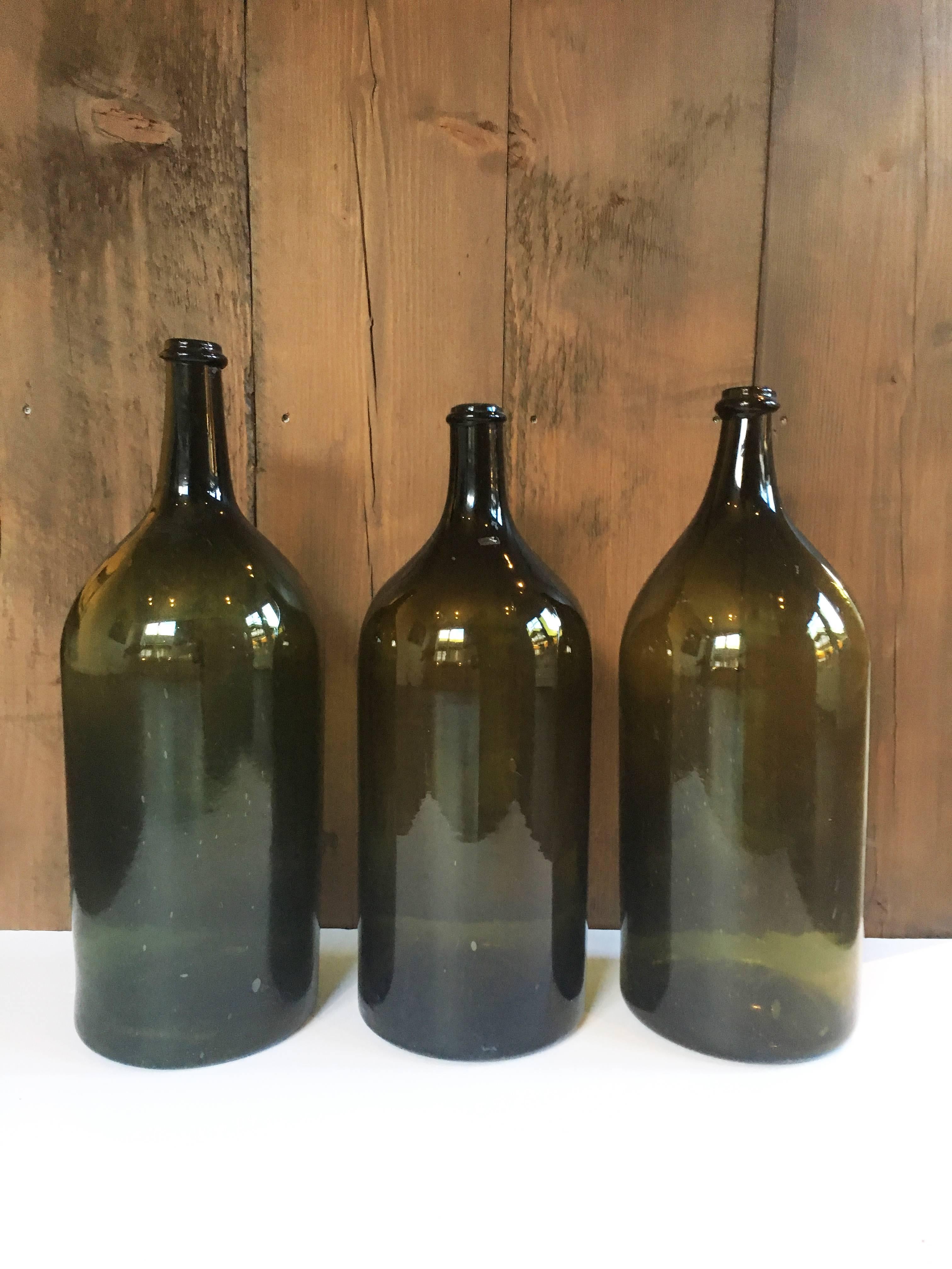 Vintage unmarked large format glass wine bottles from France. Mid-19th century, circa 1860. 

Green glass varies from olive to darker hunter green. 

Please inquire for individual measurements; priced individually.