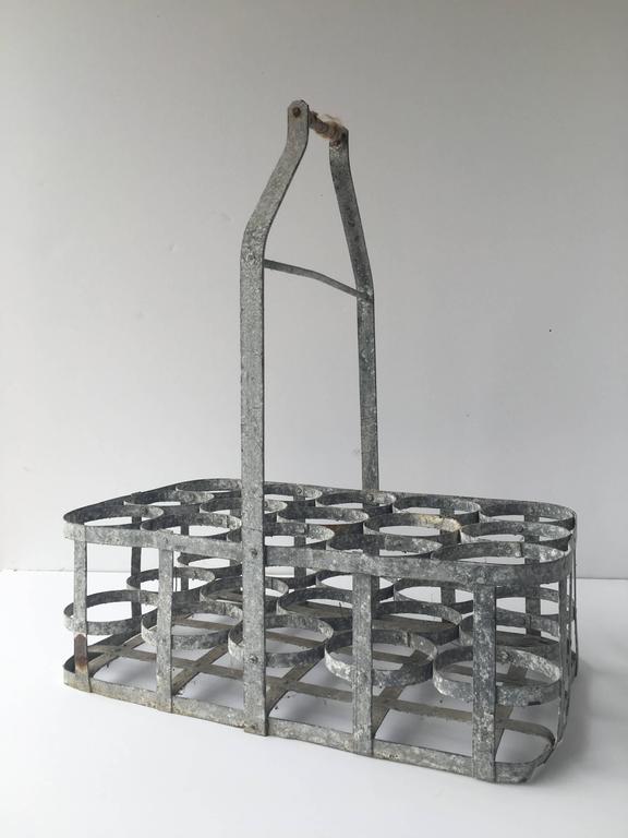 Vintage 15 slot metal milk/wine bottle carrier from Belgium with a twine handle. Vintage condition.

