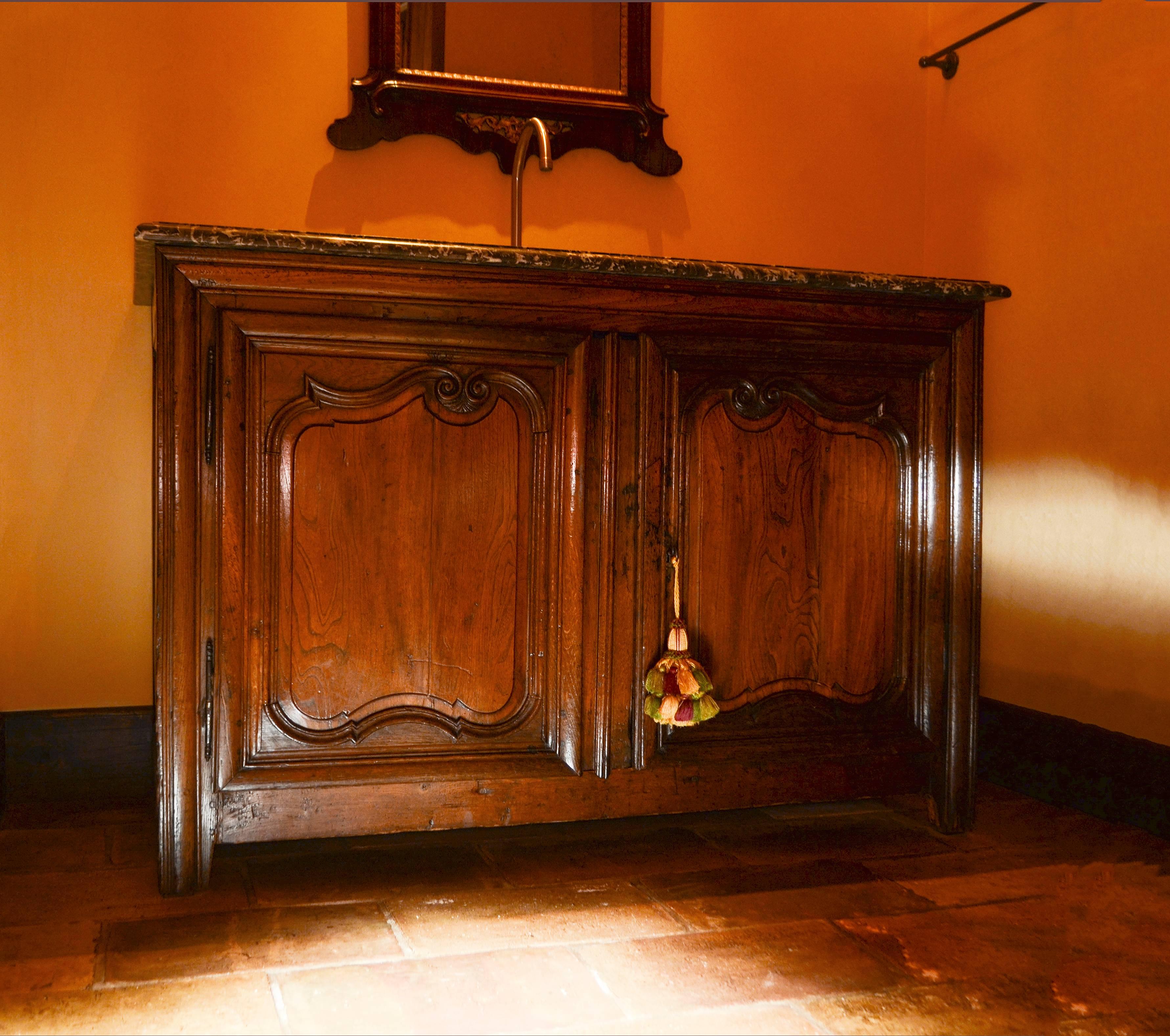 Louis XIV walnut buffet by Jeffrey Miller Design, circa late 17th century with rectangular marble top, two carved doors and shaped straight feet. Converted to bathroom vanity with dropped sink.