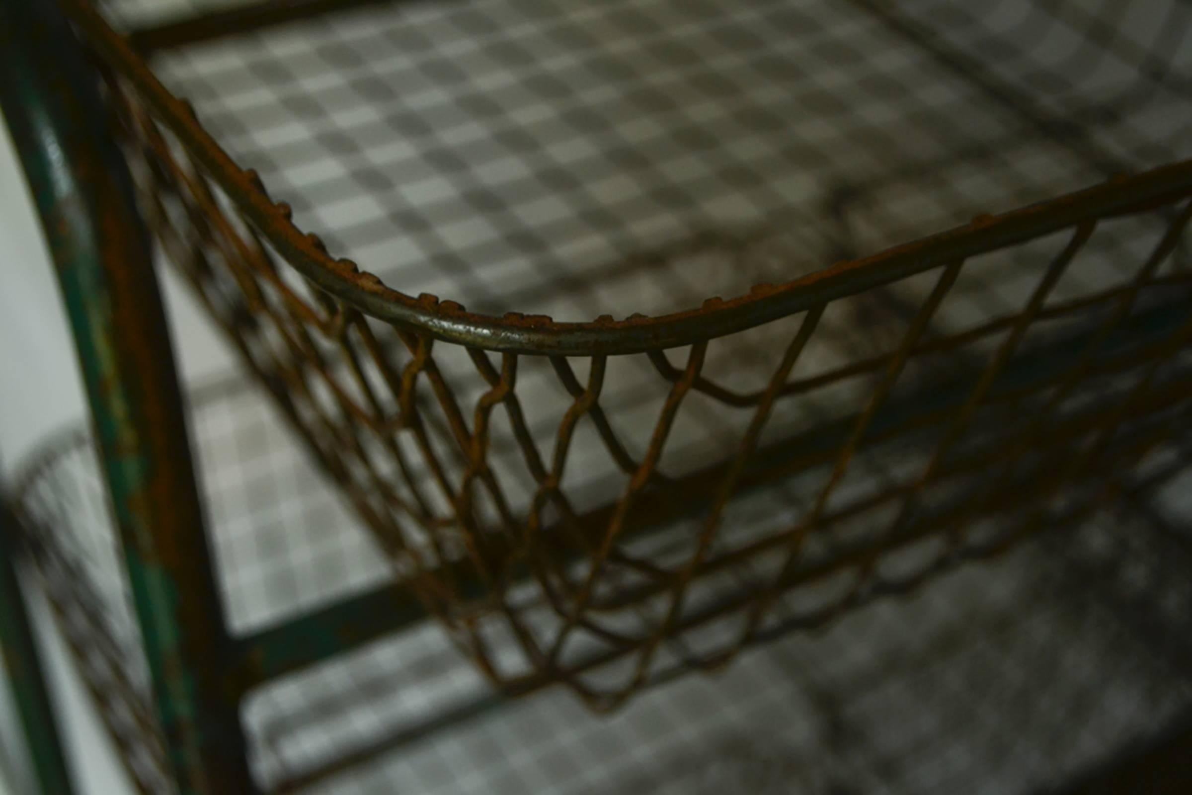 Vintage metal storage rack on casters. Painted green; please see images for detail of surface patina. 

Nine baskets for storage. Each 6 1/4 x 16 1/2 x 20 1/4 inches.