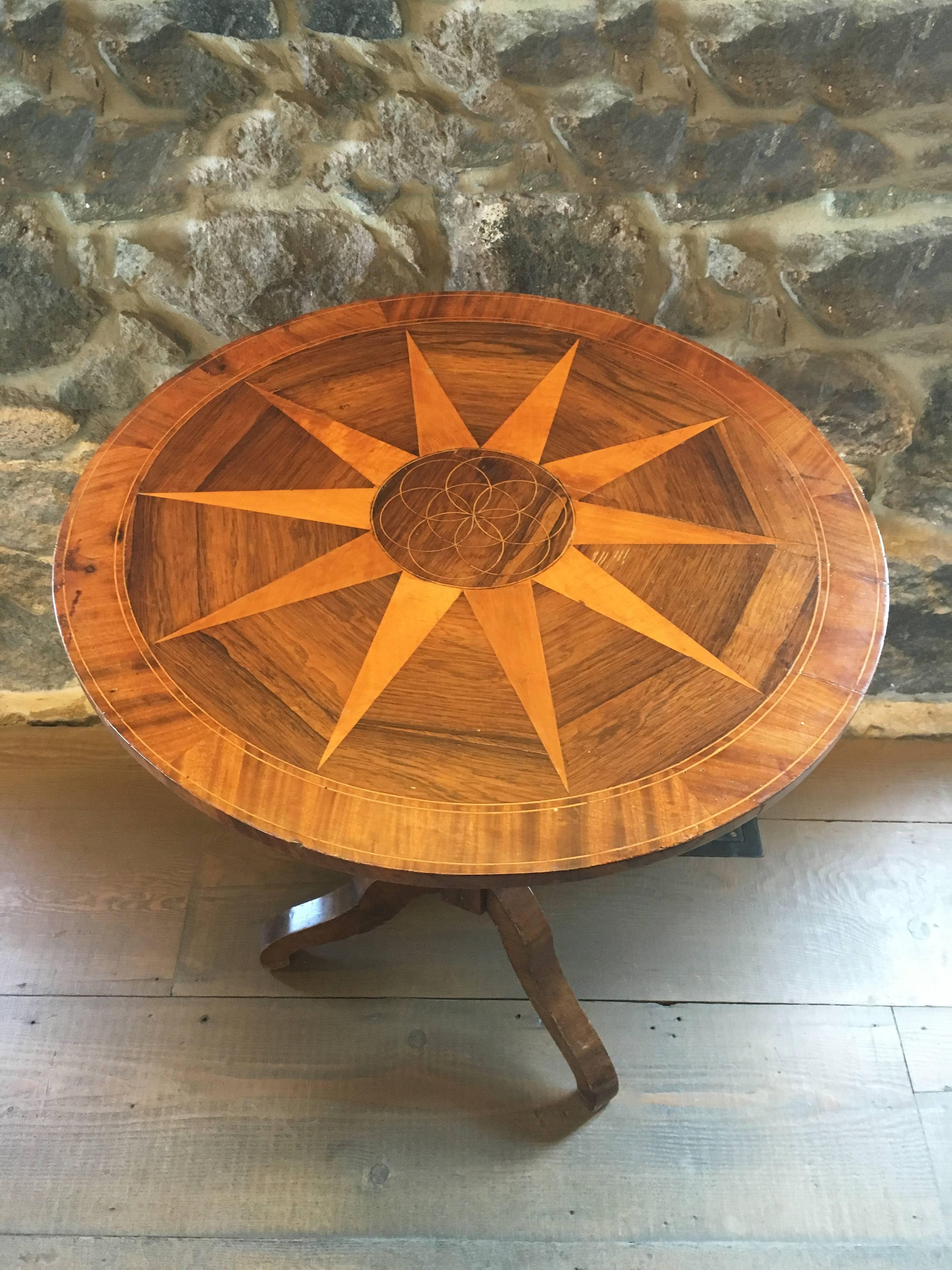Vintage hinged marquetry side table with star and elliptical motif. Hexagonal pedestal base with three legs.